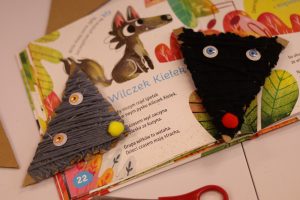 Dwie prace przedstawiające zwierzątka leśne leżą na otwartej książce.