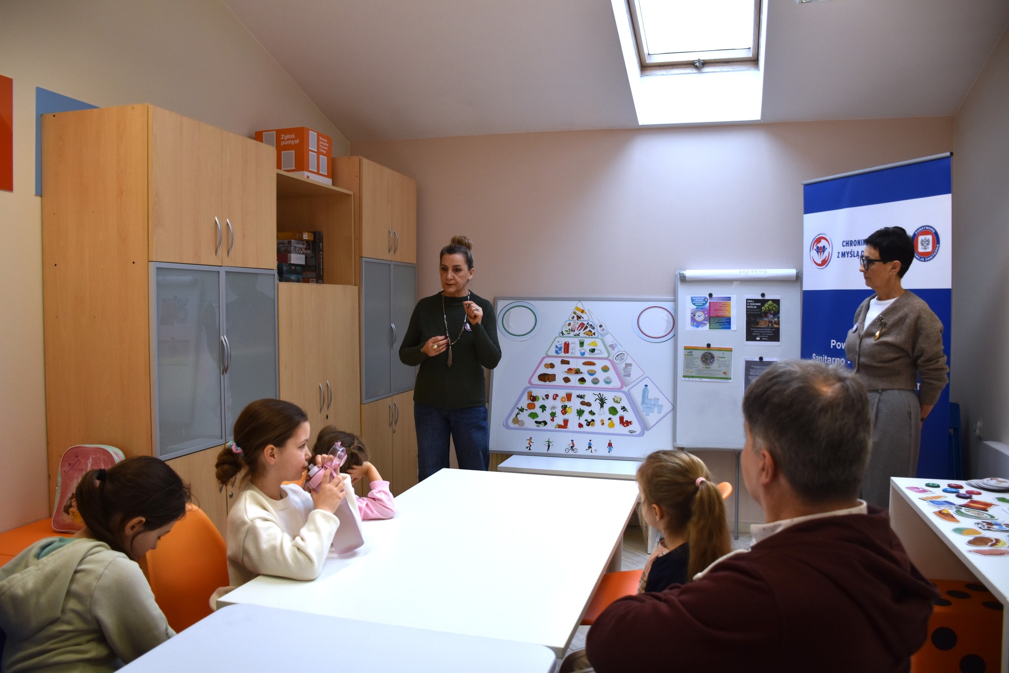 Pracownicy Stacji Sanitarno-Epidemiologicznej pokazują dzieciom piramidę żywności