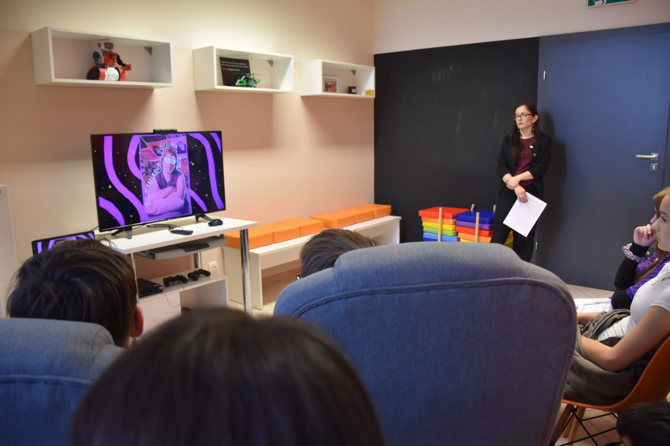 Młodzież i prawadząca spotkanie oglądają filmik