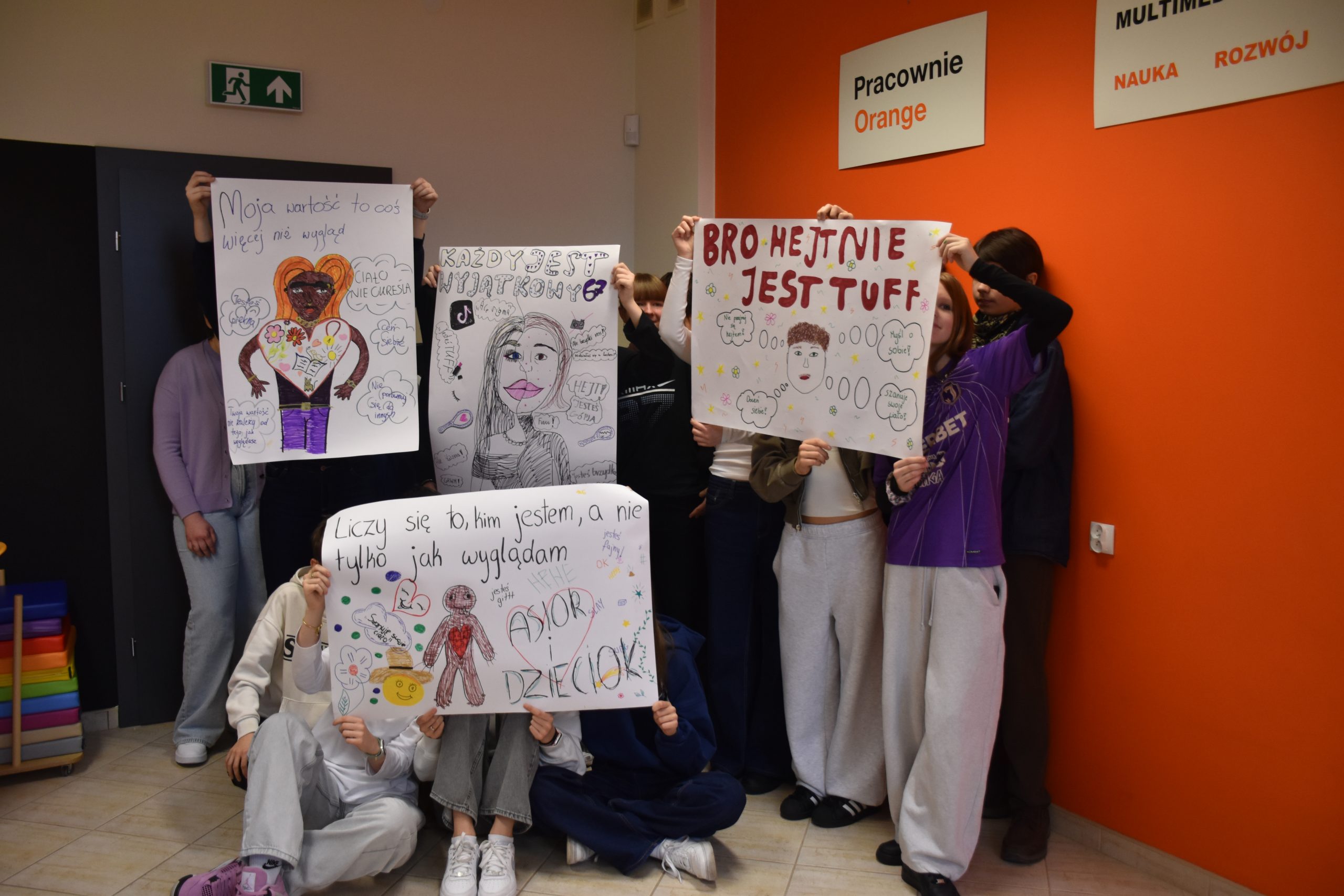 Młodzież trzymająca stworzone przez siebie plakaty