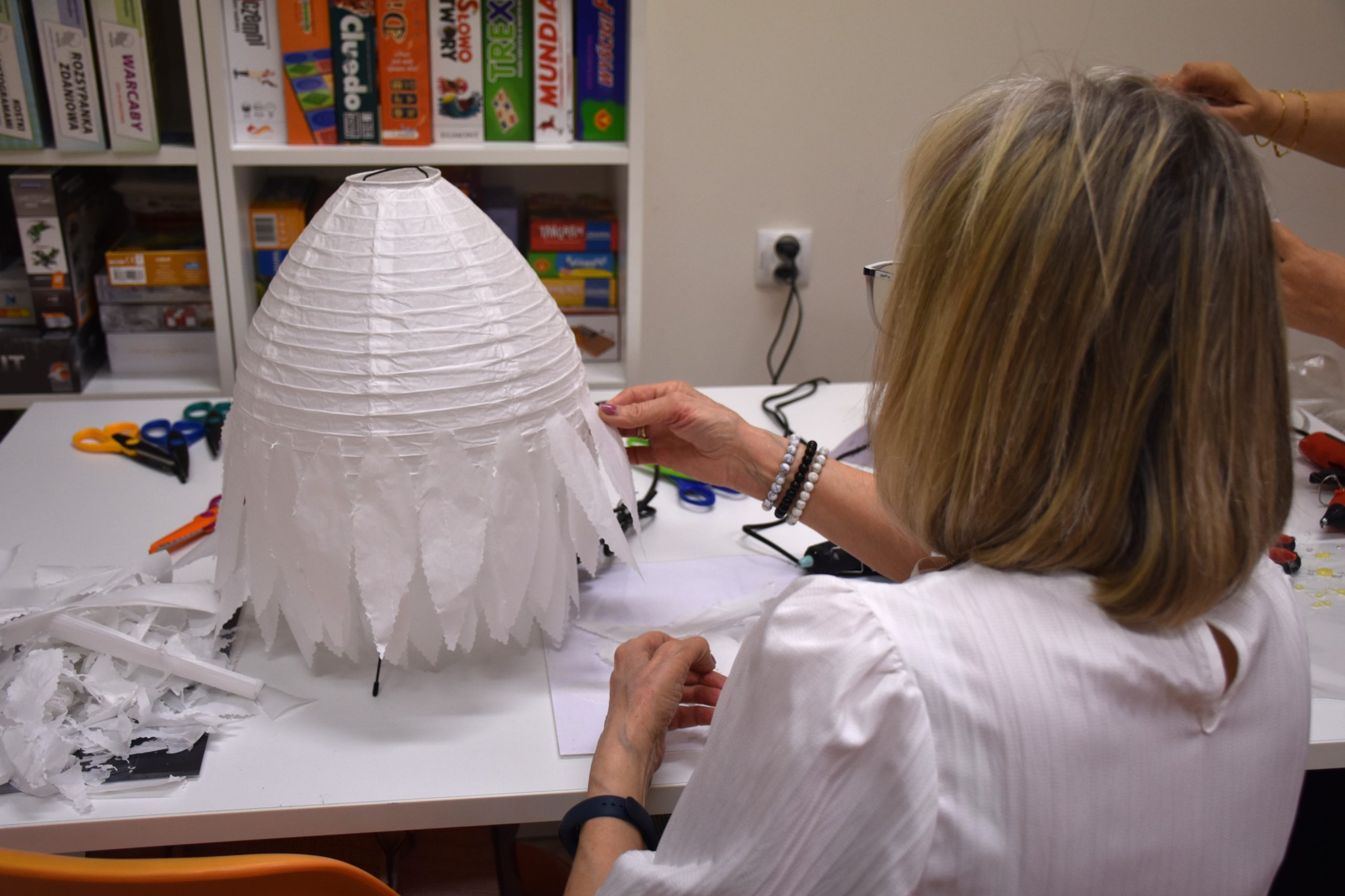 Kobieta przykleja elementy lampki