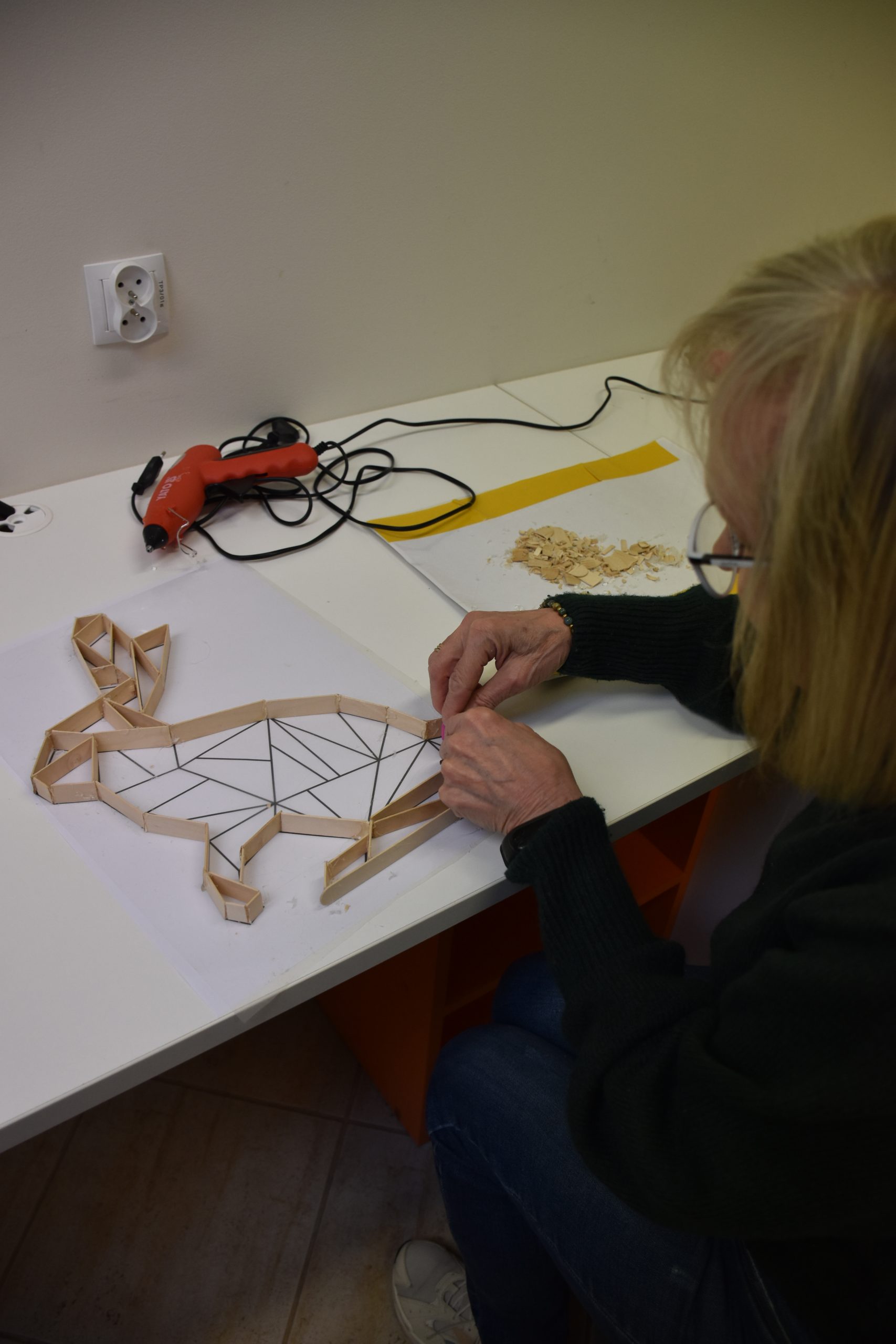 kobieta przykleja patyczki do zająca