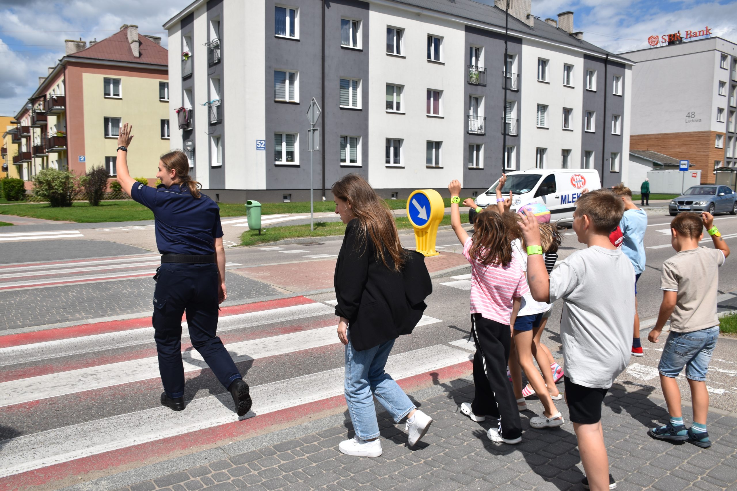 policjantka przeprowadza dzieci przez ulicę