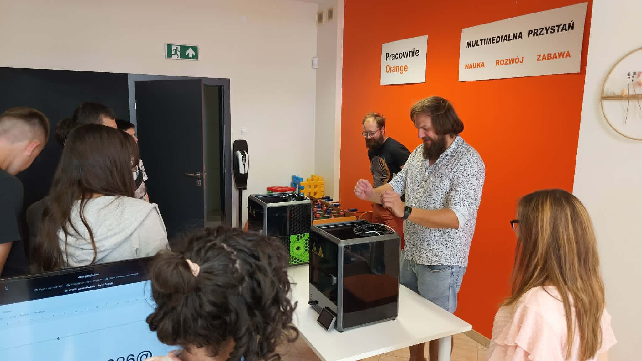 Prowadzący pokazują uczestnikom drukarkę 3D