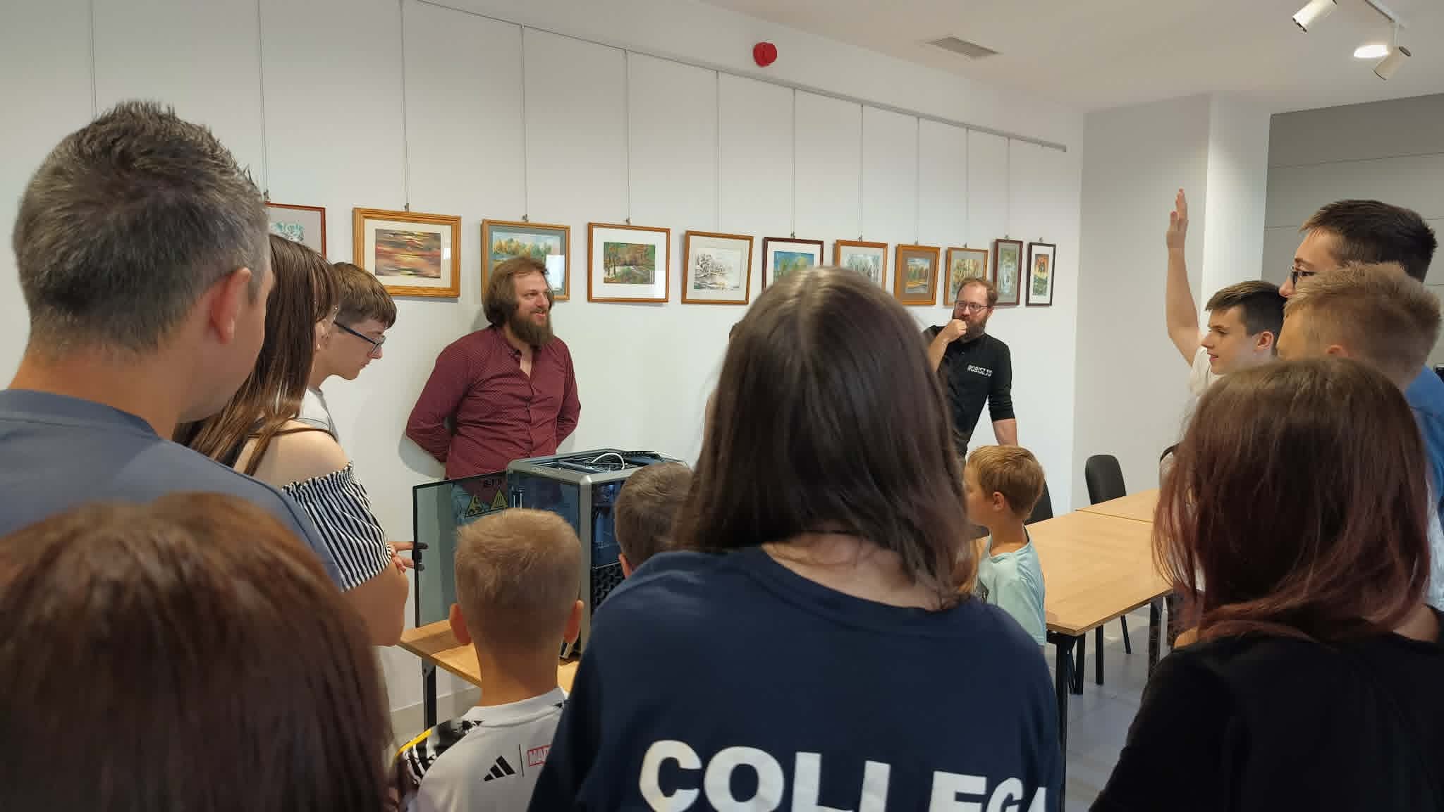 dzieci i młodzież słuchają prowadzącego zajęcia