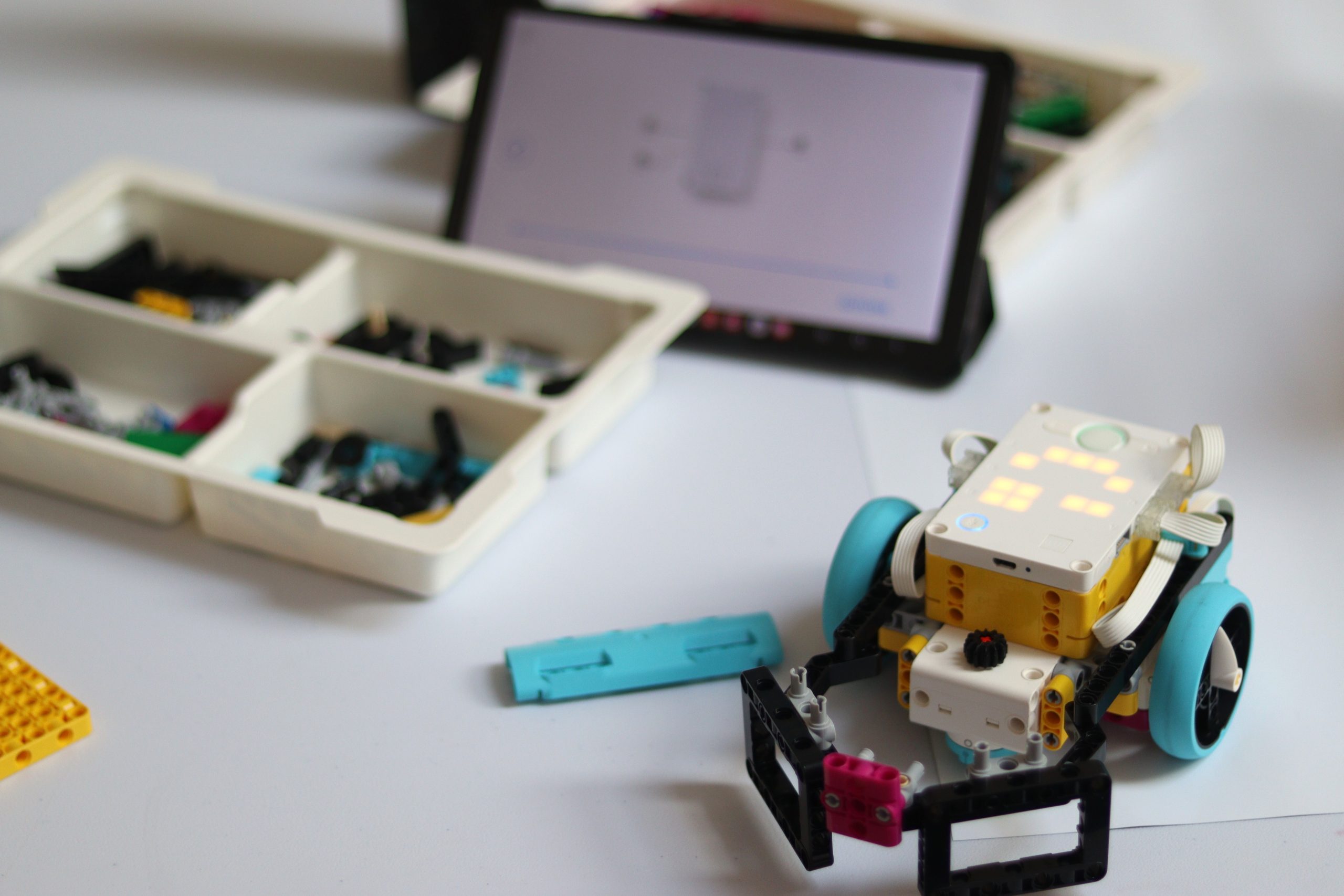 Na stole robot LEGO, klocki i tablet