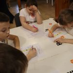 grupa dzieci rozwiązujących krzyżówkę