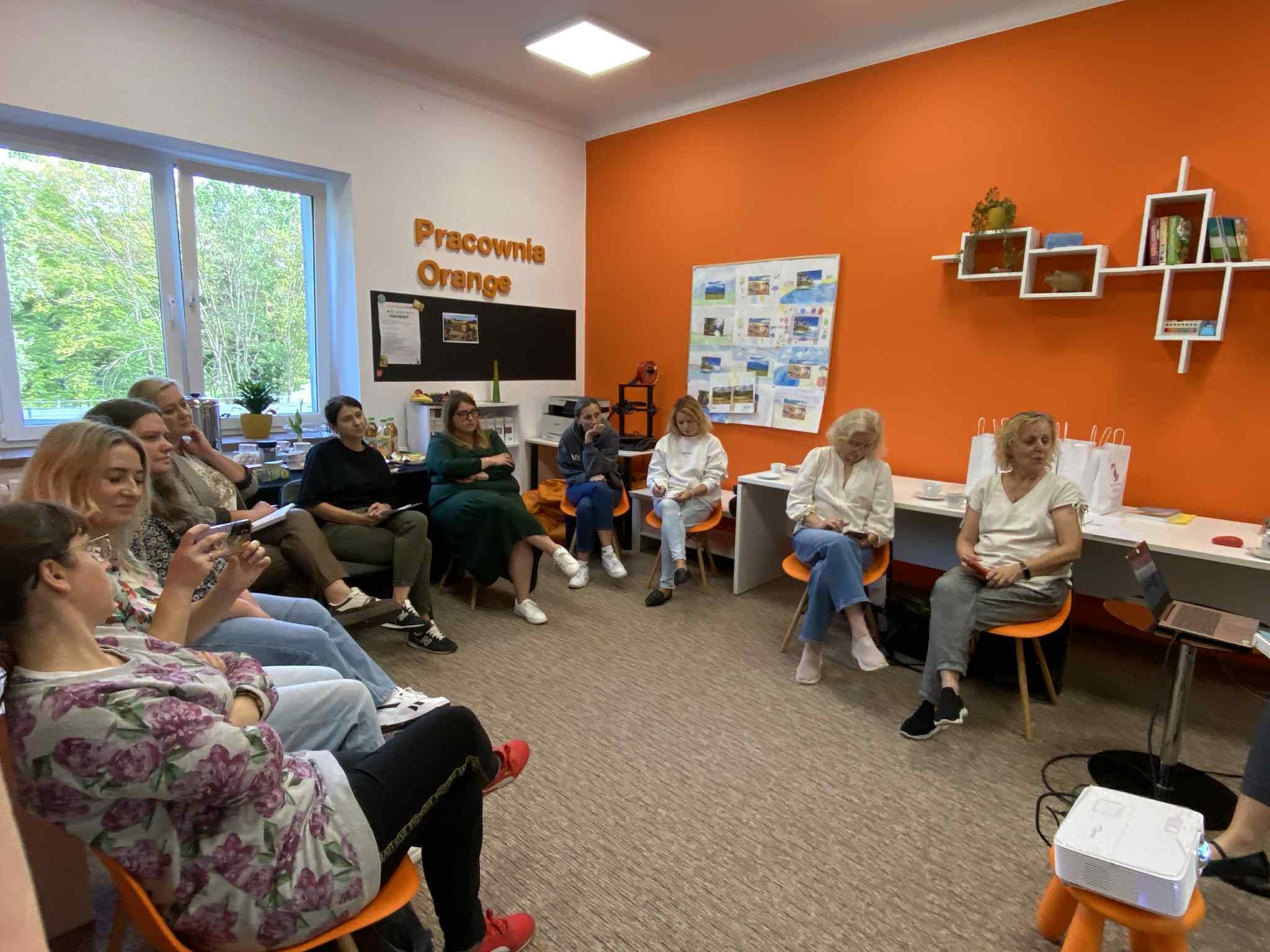 Grupa osób siedzących w Pracowni Orange