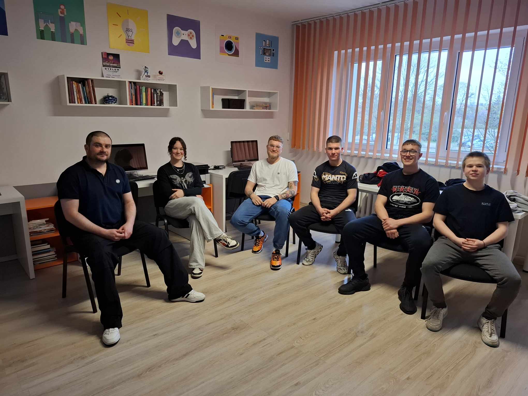 Grupa mężczyzn siedzi w kręgu na krzesłach.