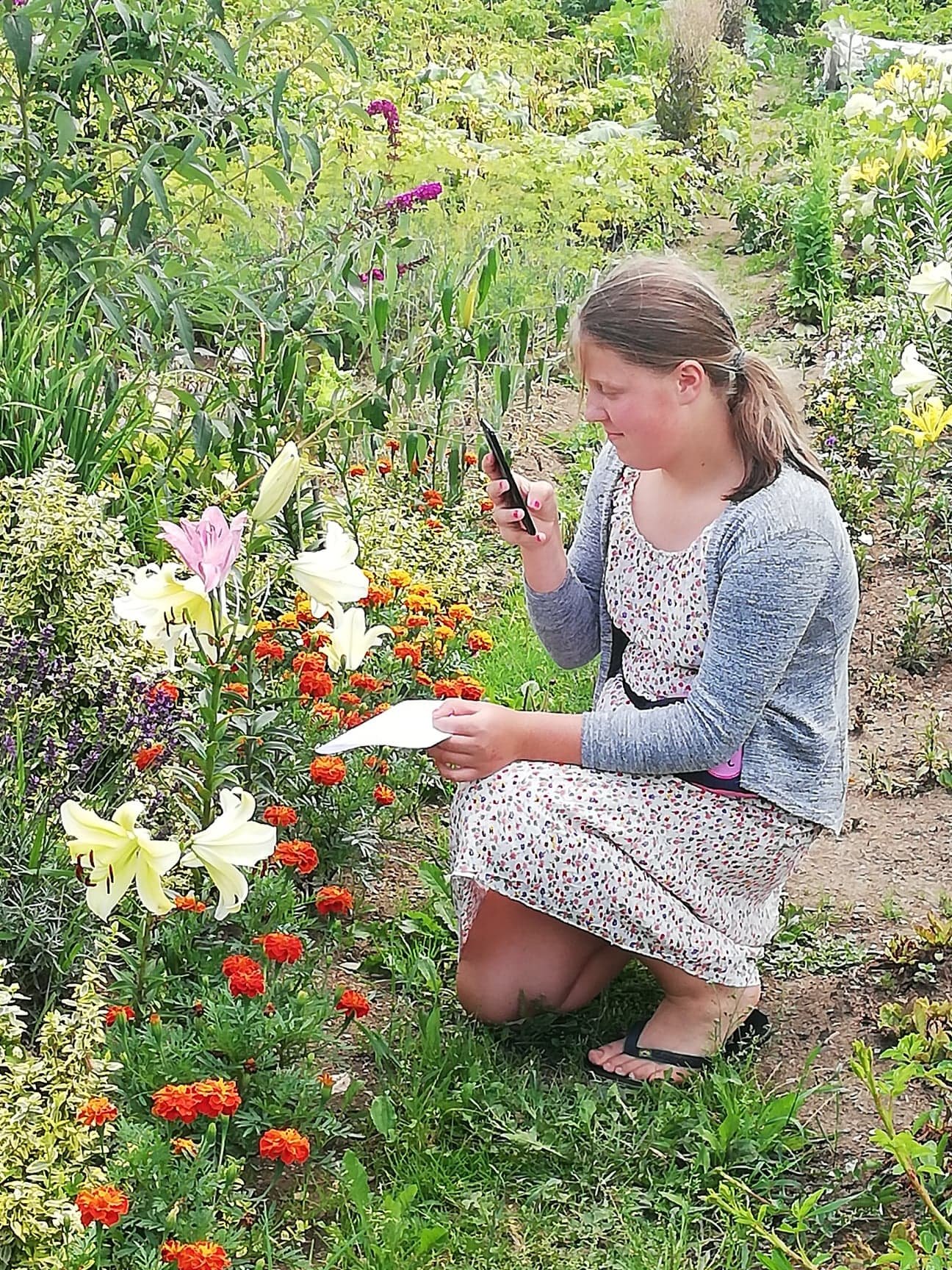 Dziewczynka fotografująca kwiaty