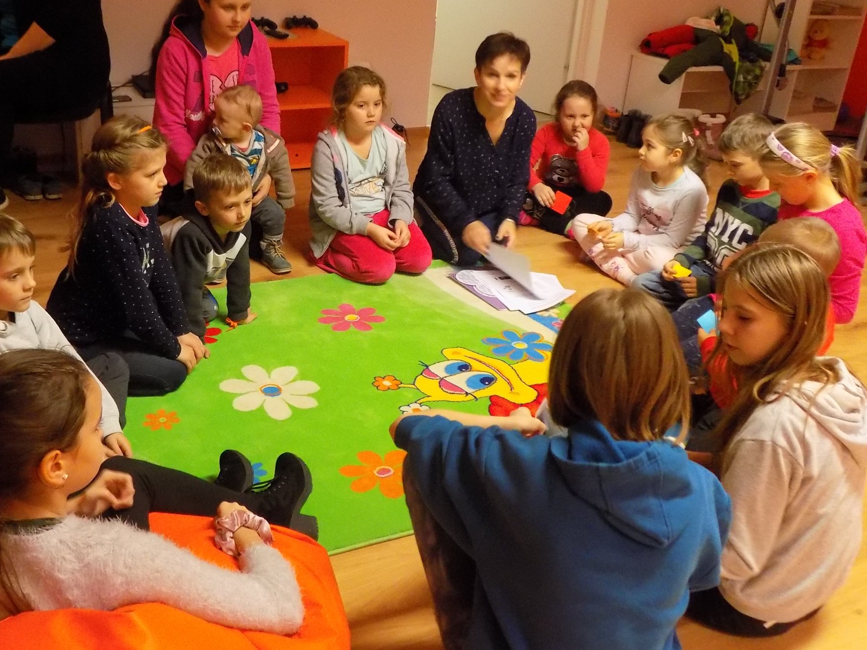 Grupa dzieci na dywanie podczas zabaw integracyjnych.