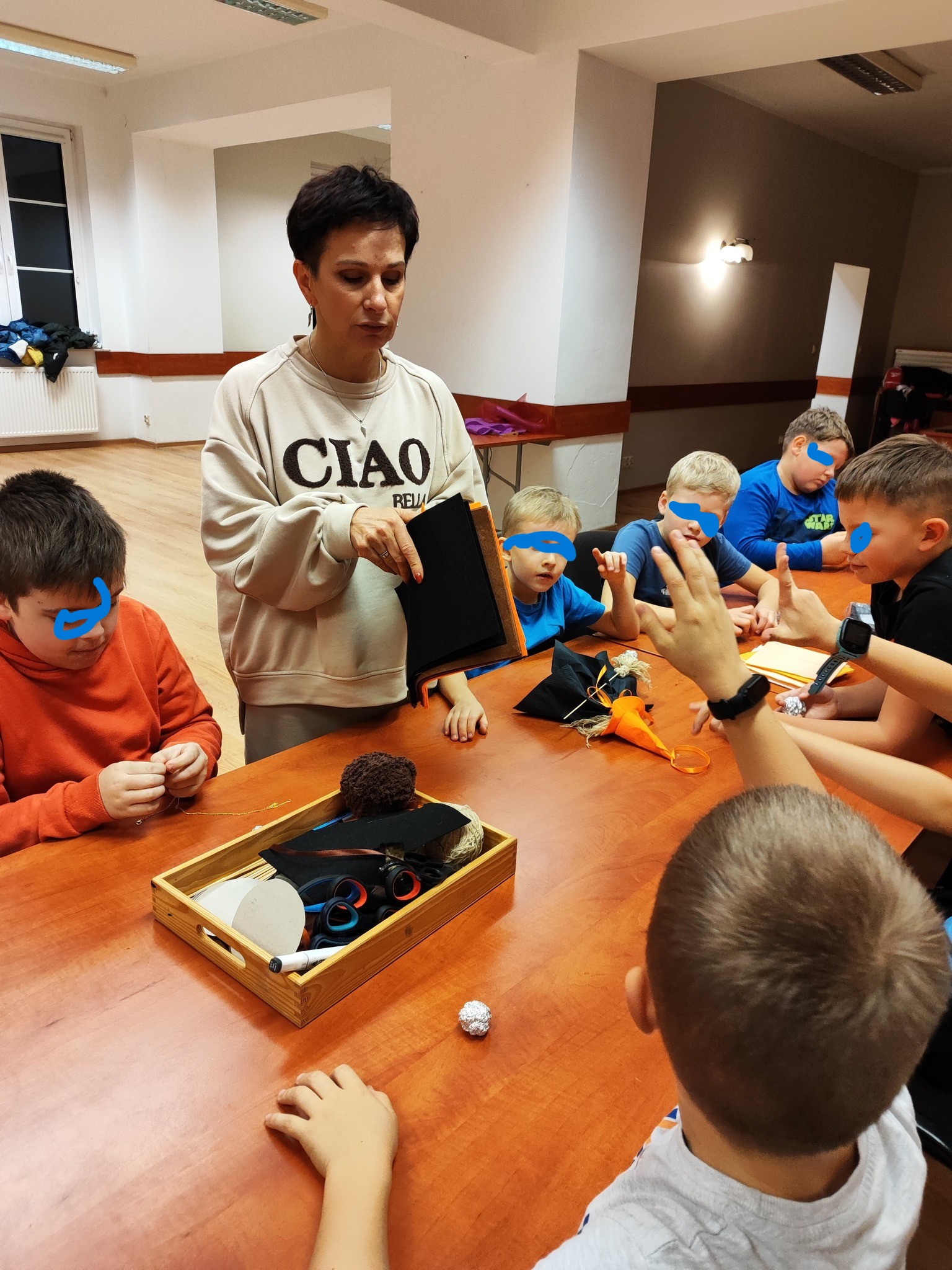 Grupa dzieci przy stole tworze ozdoby.