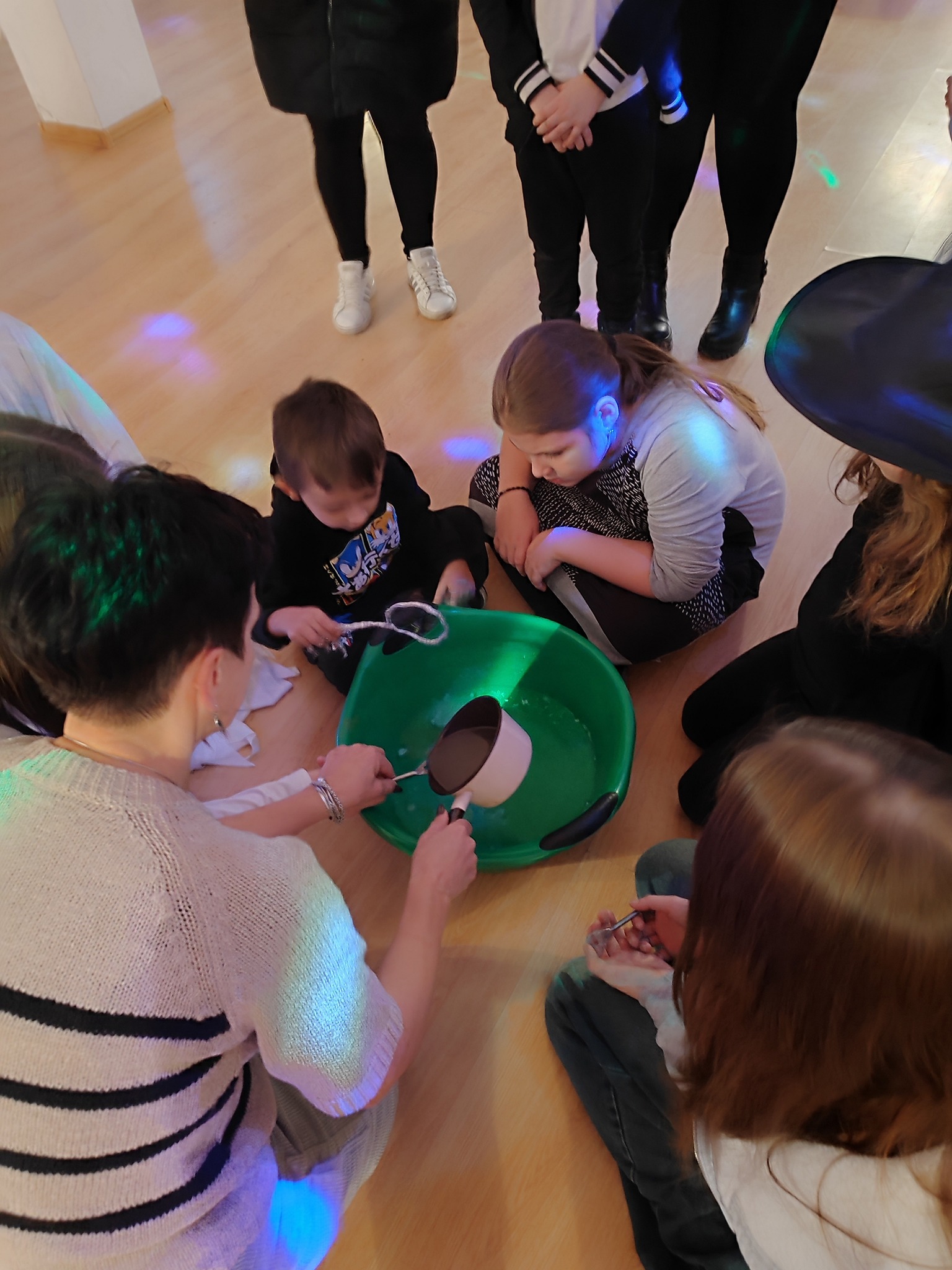 na zdjęciu grupa dzieci - lanie wosku przez klucz