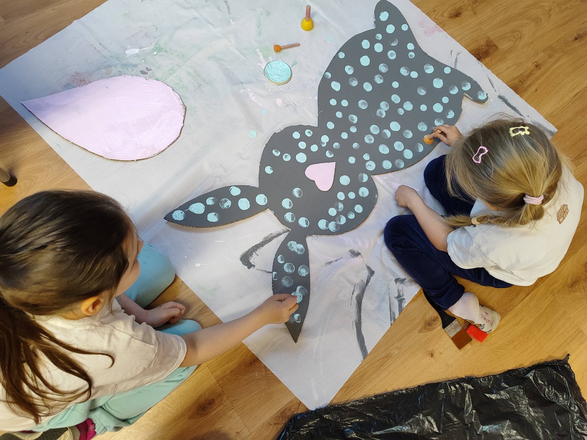 dziewczynki malują wzorki na zającu