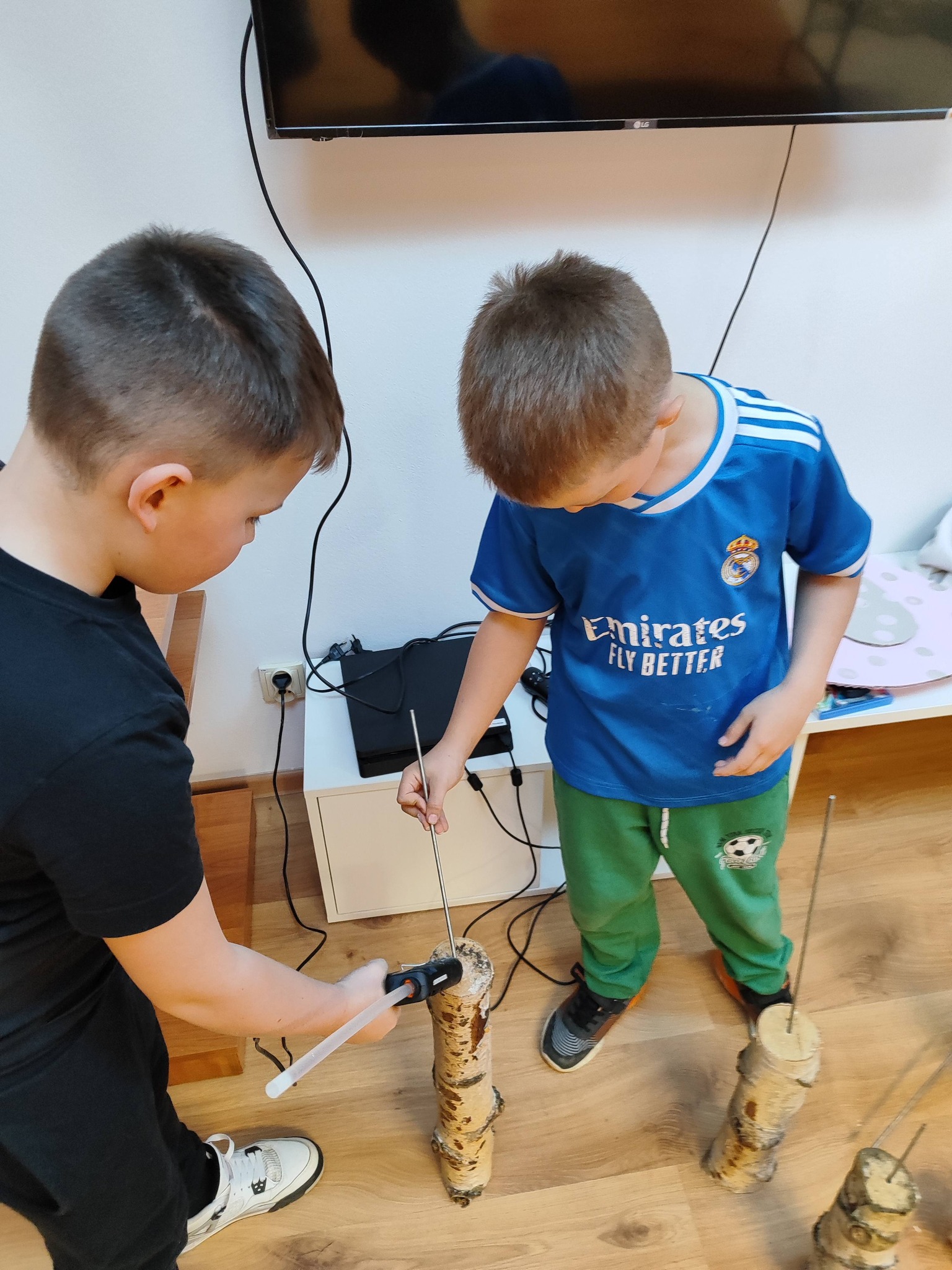 chłopcy montują druty w pieńkach brzozy