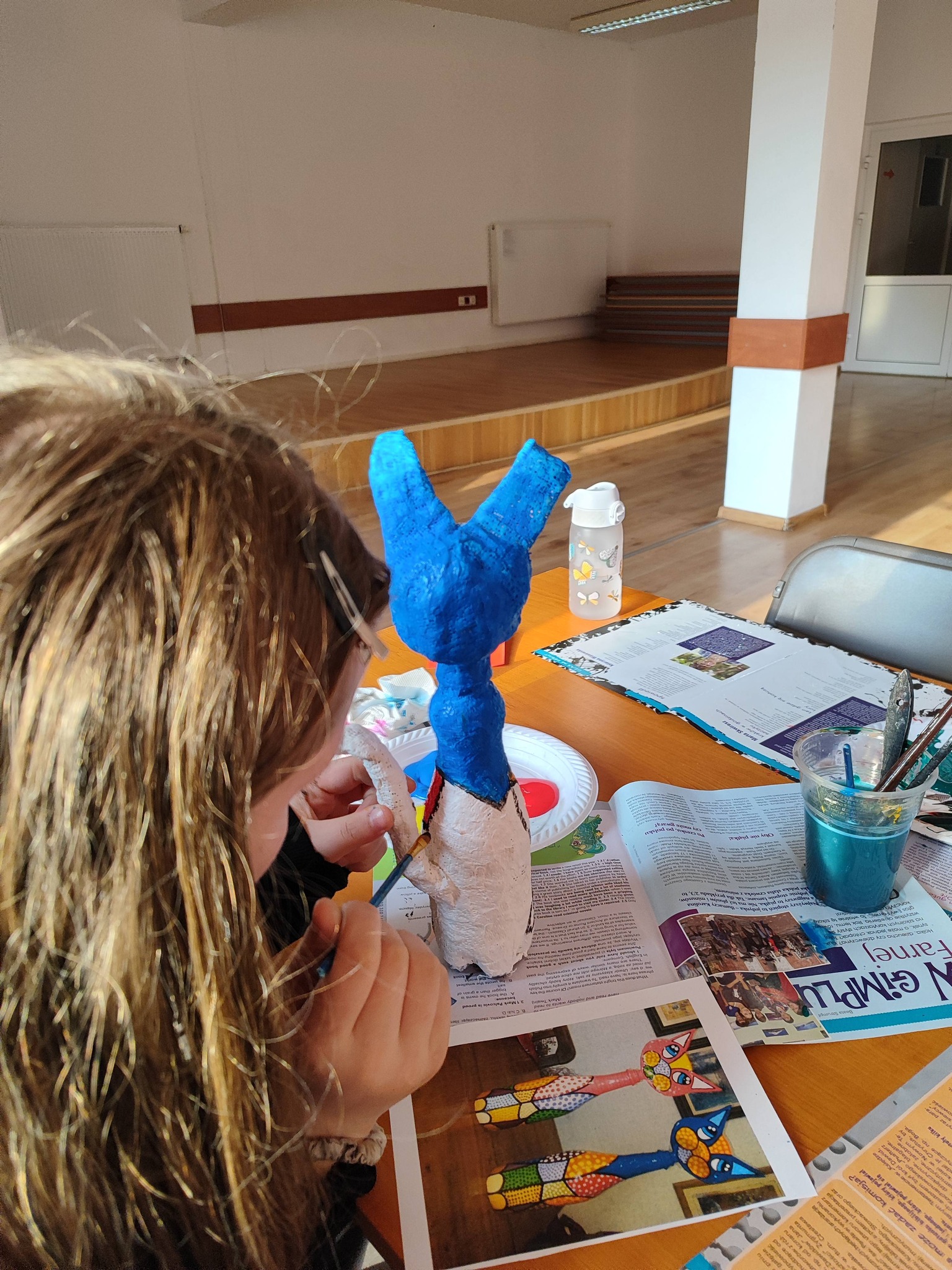 dziewczynka maluje figurkę kota