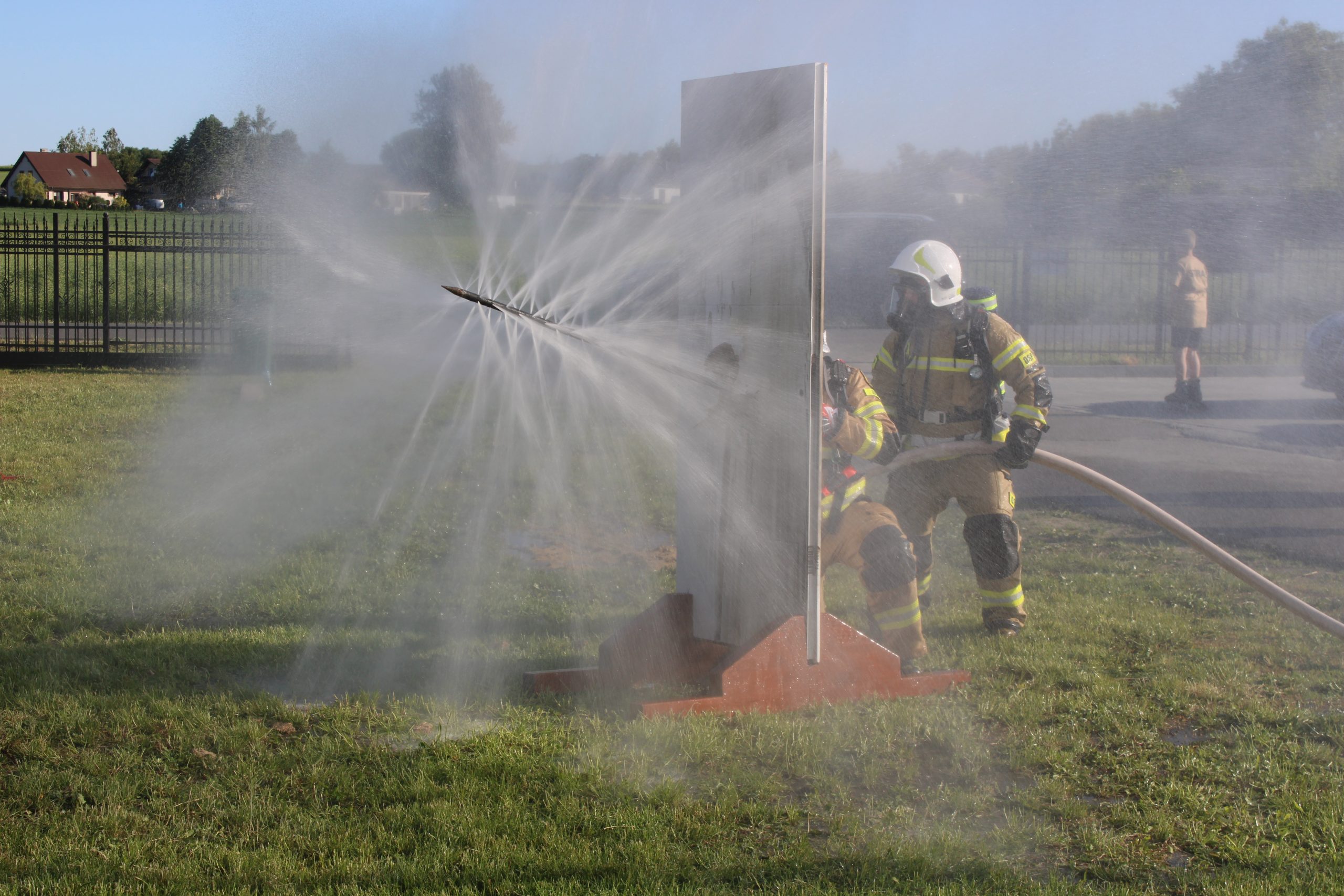 Na zdjęciu widać fontannę wodną i strażaka
