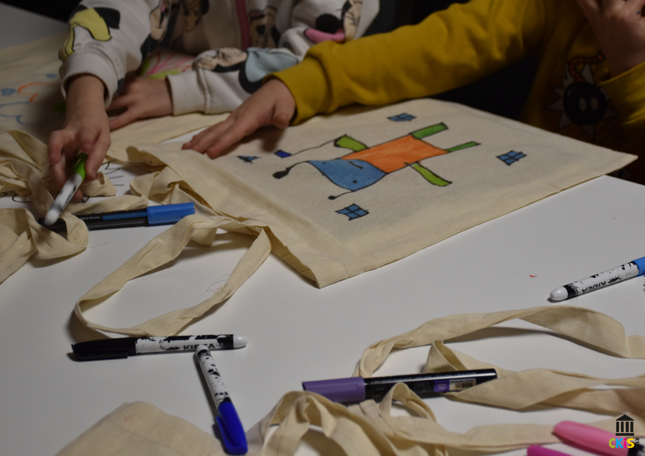 na zdjęciu widać torbę płócienną, na niej namalowany robot. Obok niej leżą pisaki.