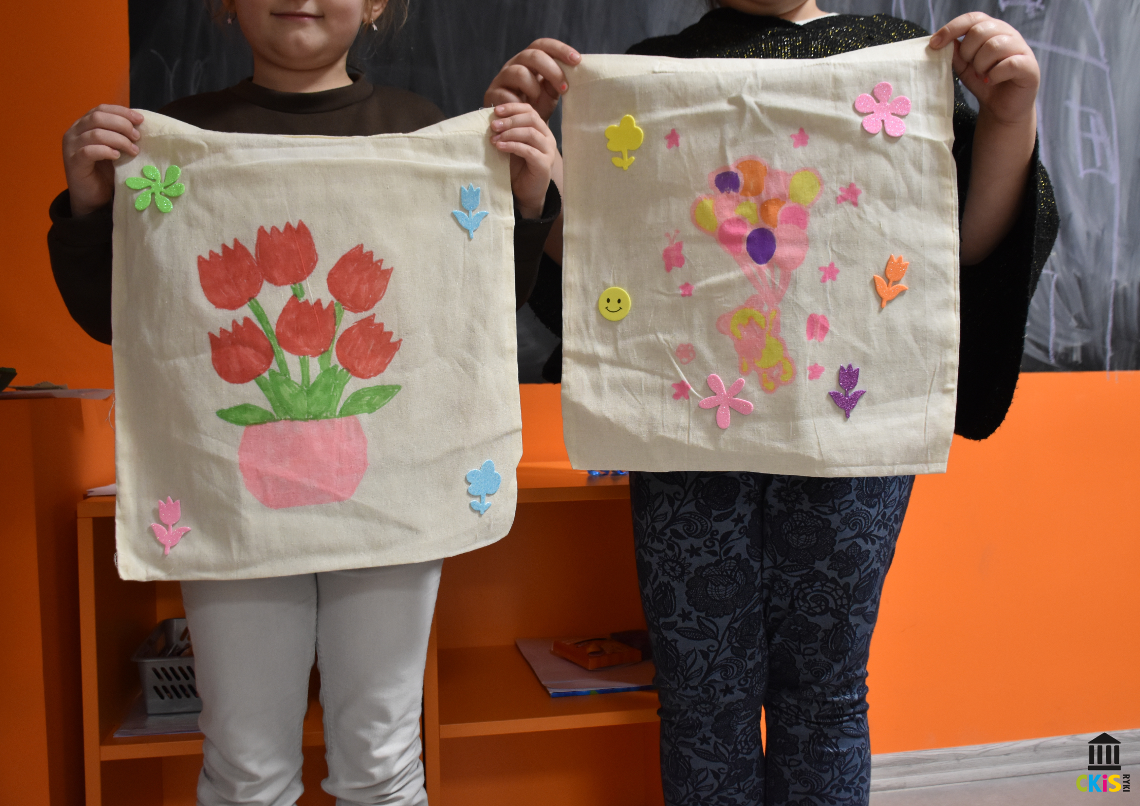 na zdjęciu widać płócienne torby , na pierwszej są narysowane tulipany w wazonie, na drugiej miś z balonami.