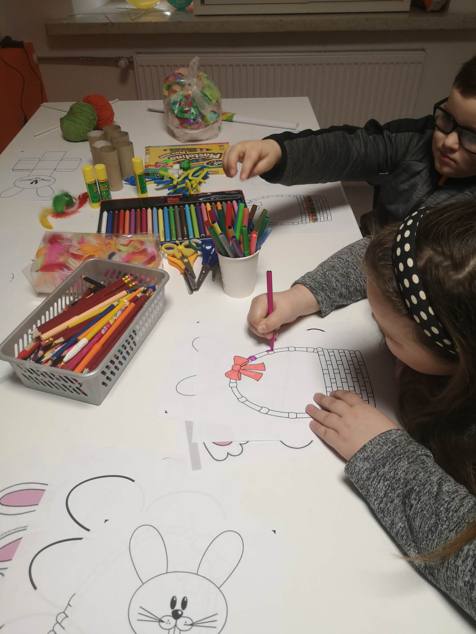 Na zdjęciu widać dzieci kolorujących obrazki