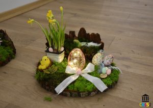 Stroik wielkanocny wykonany z mchu, kory z ozdobami wielkanocnymi