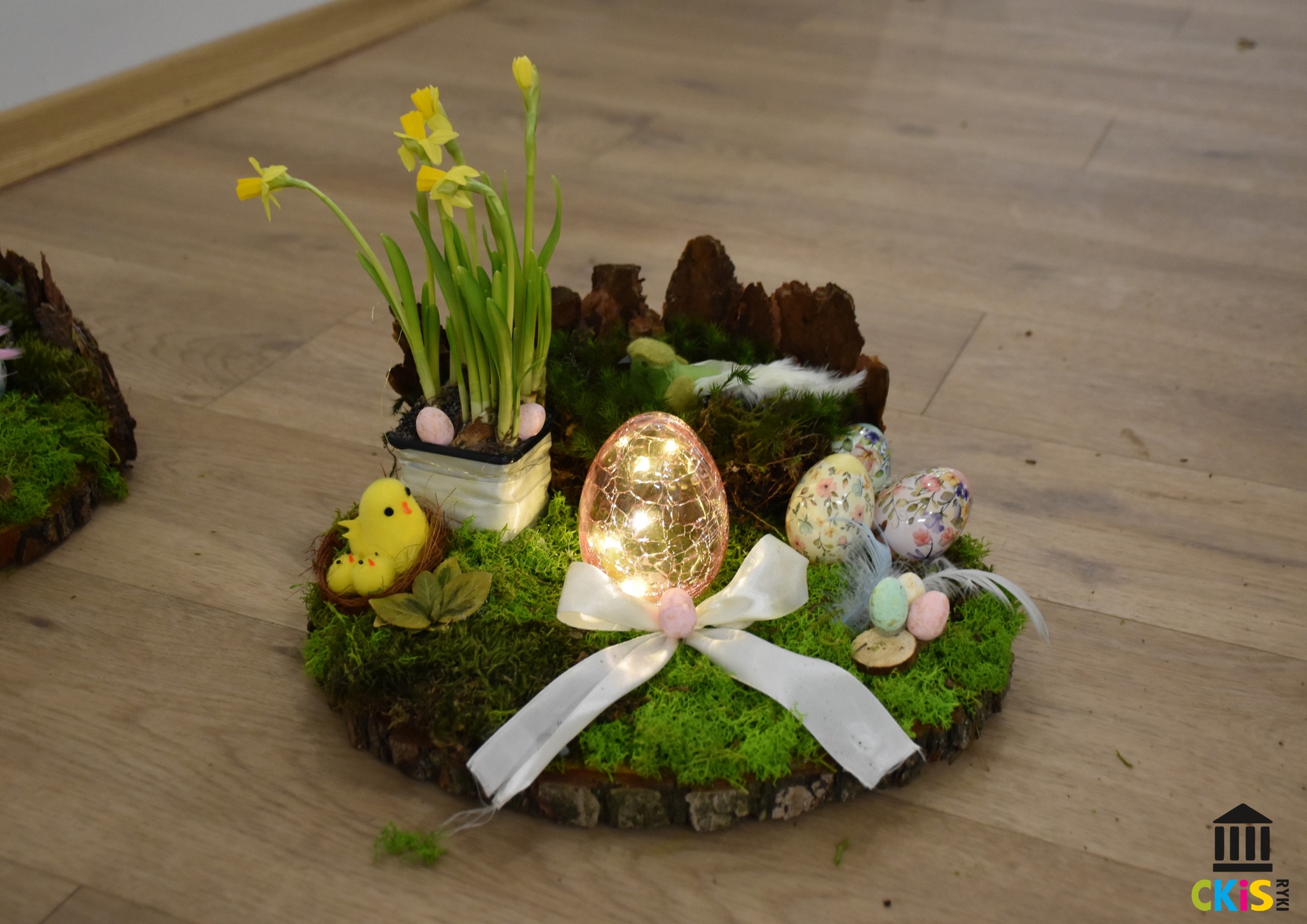 Stroik wielkanocny wykonany z mchu, kory z ozdobami wielkanocnymi