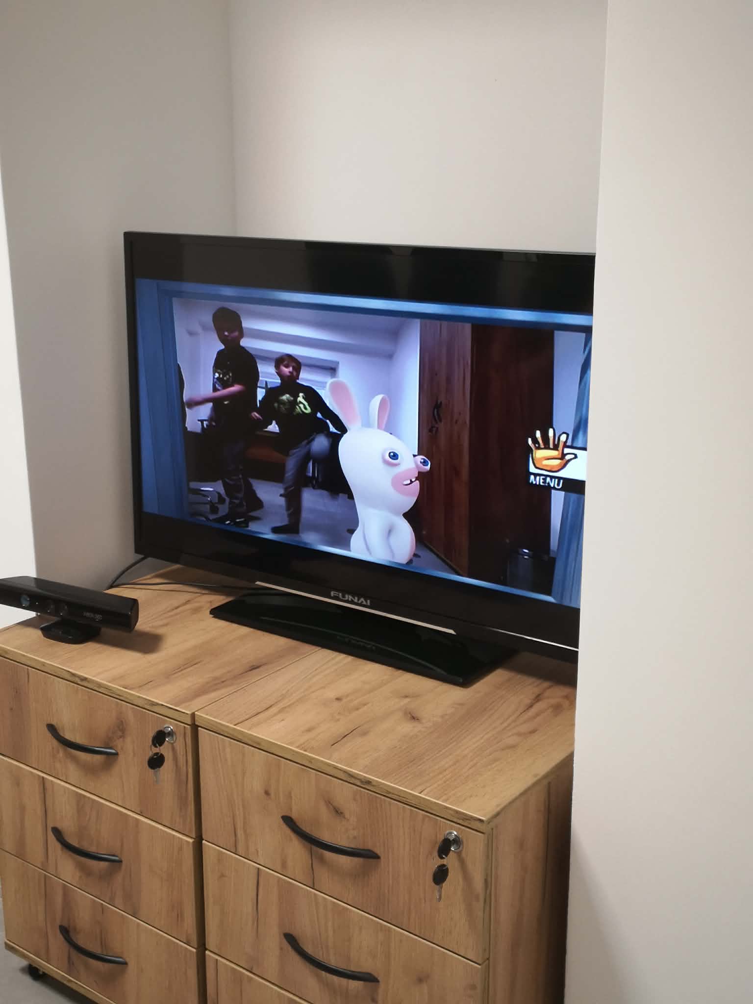 na obrazku widać ekran telewizora. Na ekranie jest włączona gra, z której korzystają dzieci.