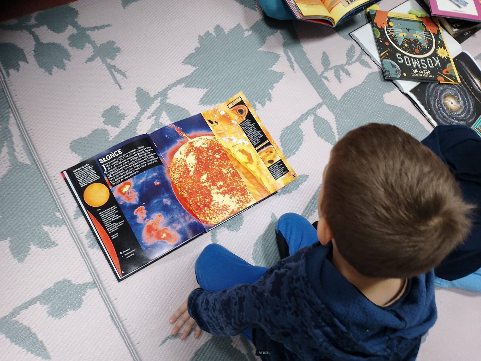 Chłopiec oglądający książkę o kosmosie.