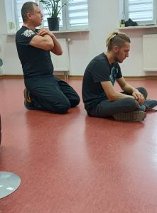 prowadzący kurs pokazuje ćwiczenie na podłodze