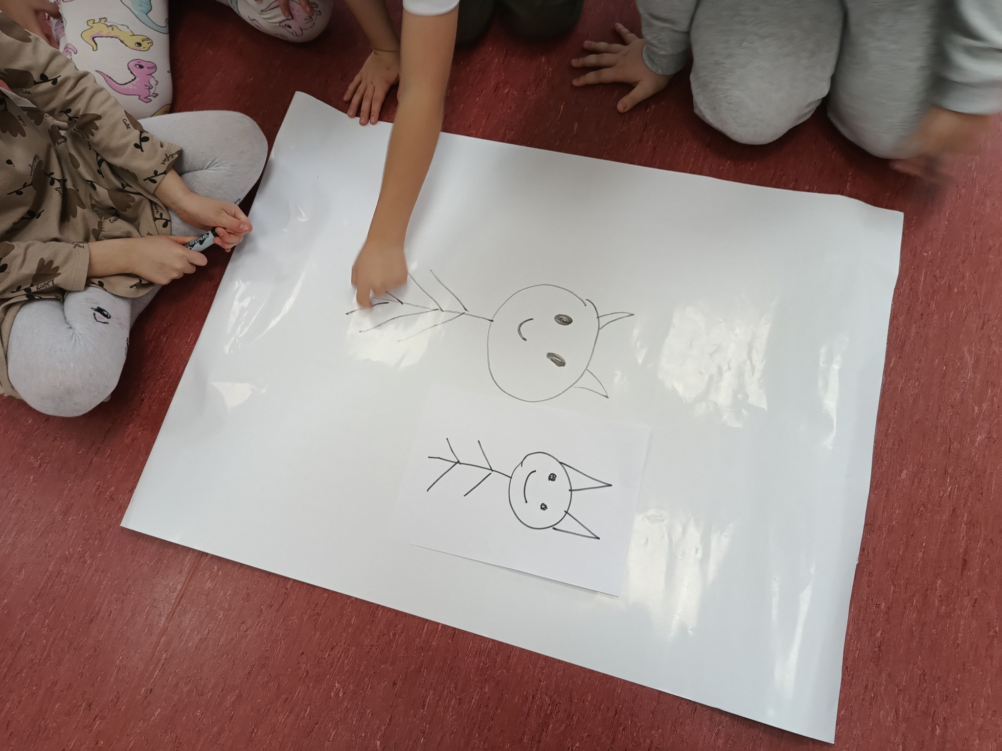 dziecko ryzuje na dużym kartonie