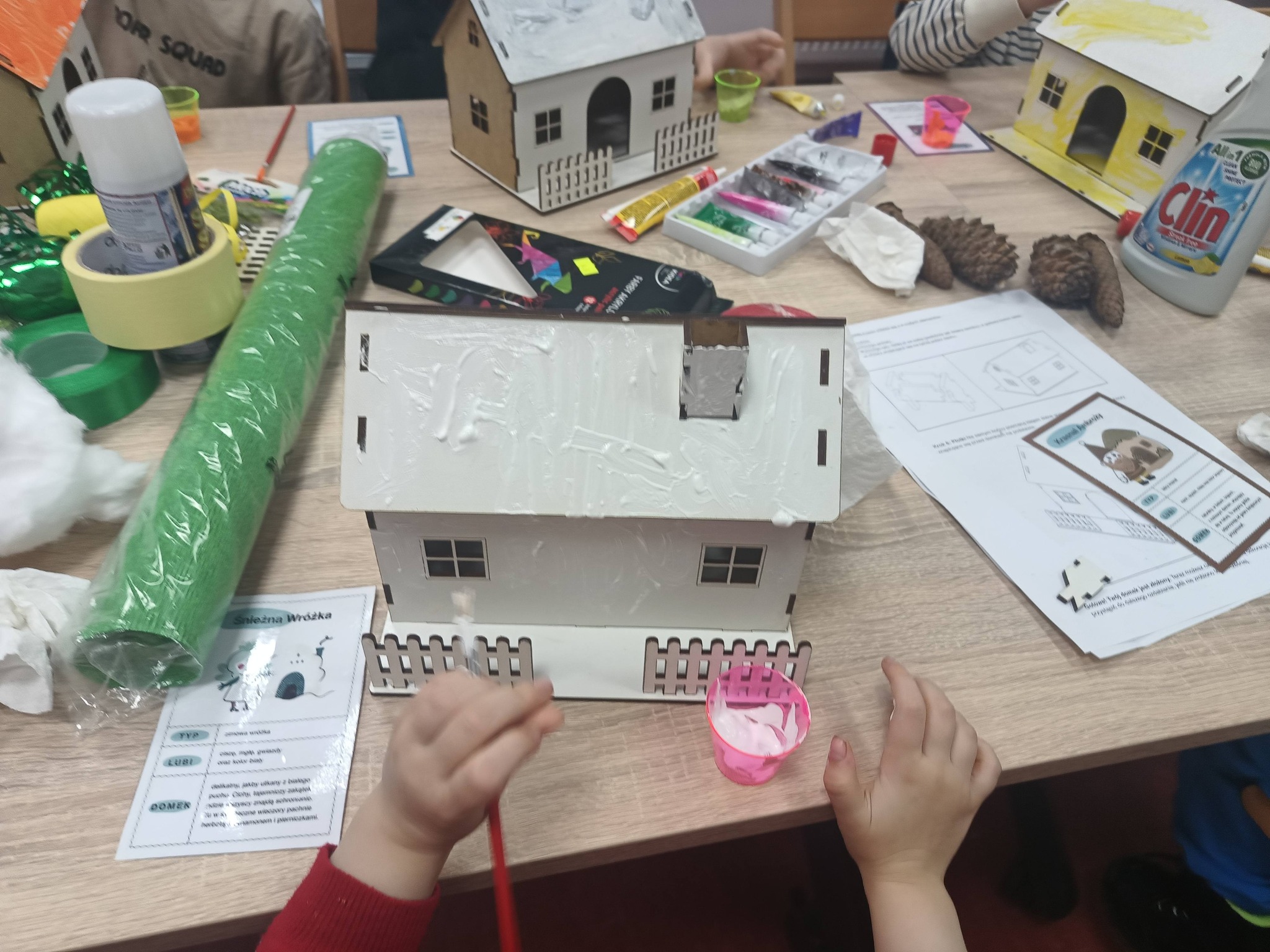 dziecko maluje domek na biało