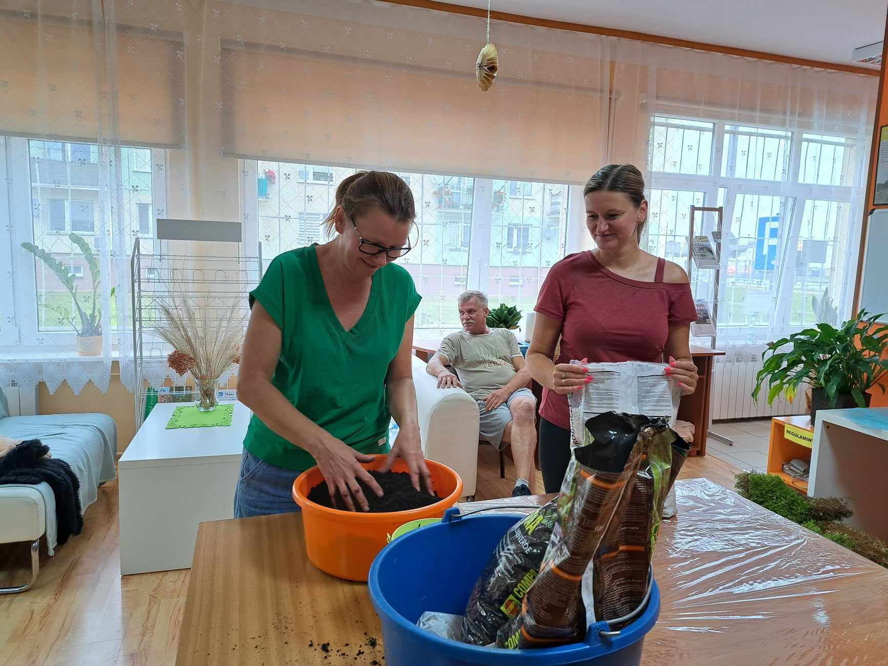 Kobiety mieszają ziemię do stworzenia kokedamy.