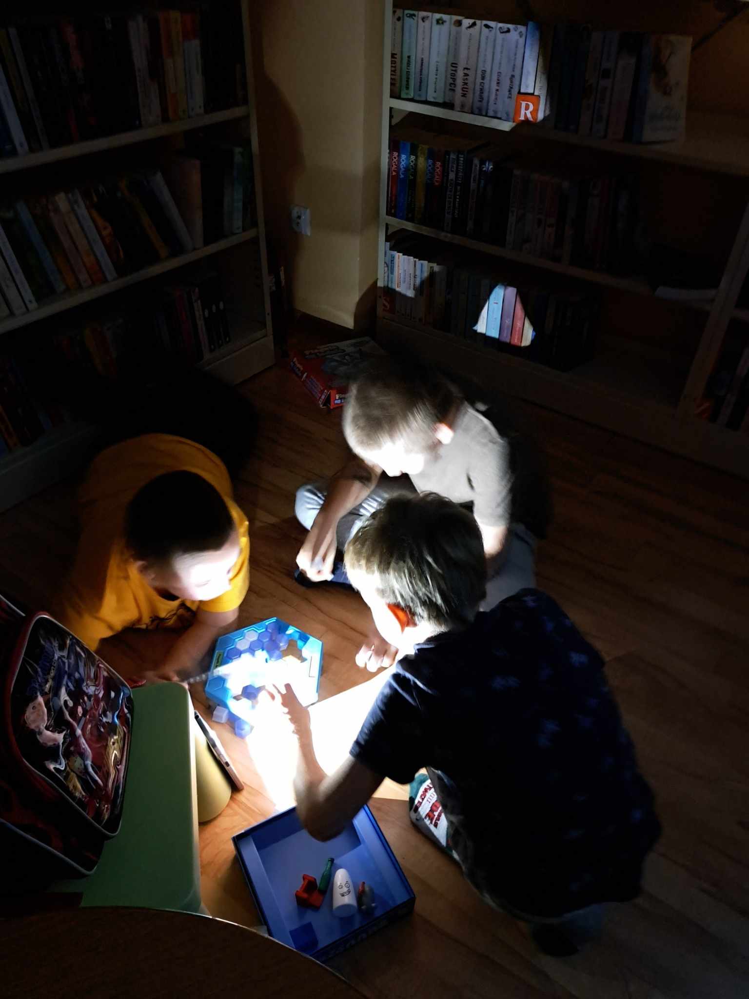 Grupa dzieci podczas gry w planszówki.