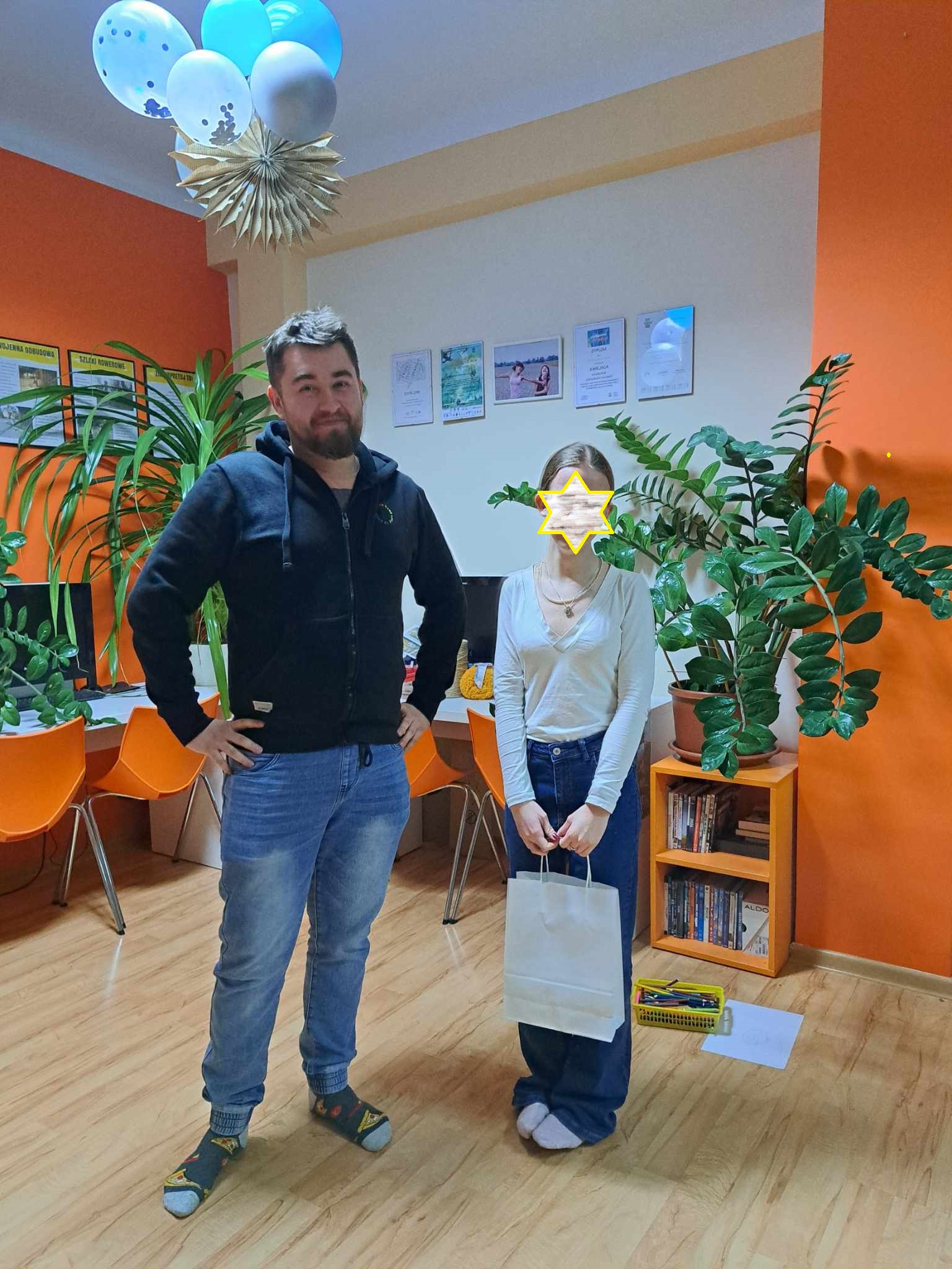 Dziewczynka pozuje do zdjęcia z otrzymaną nagrodą. Obok pan Adrian.