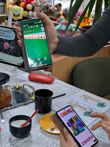 Na zdjęciu widać dłonie, które trzymają telefony z otwartymi aplikacjami do ćwiczenia uwagi.