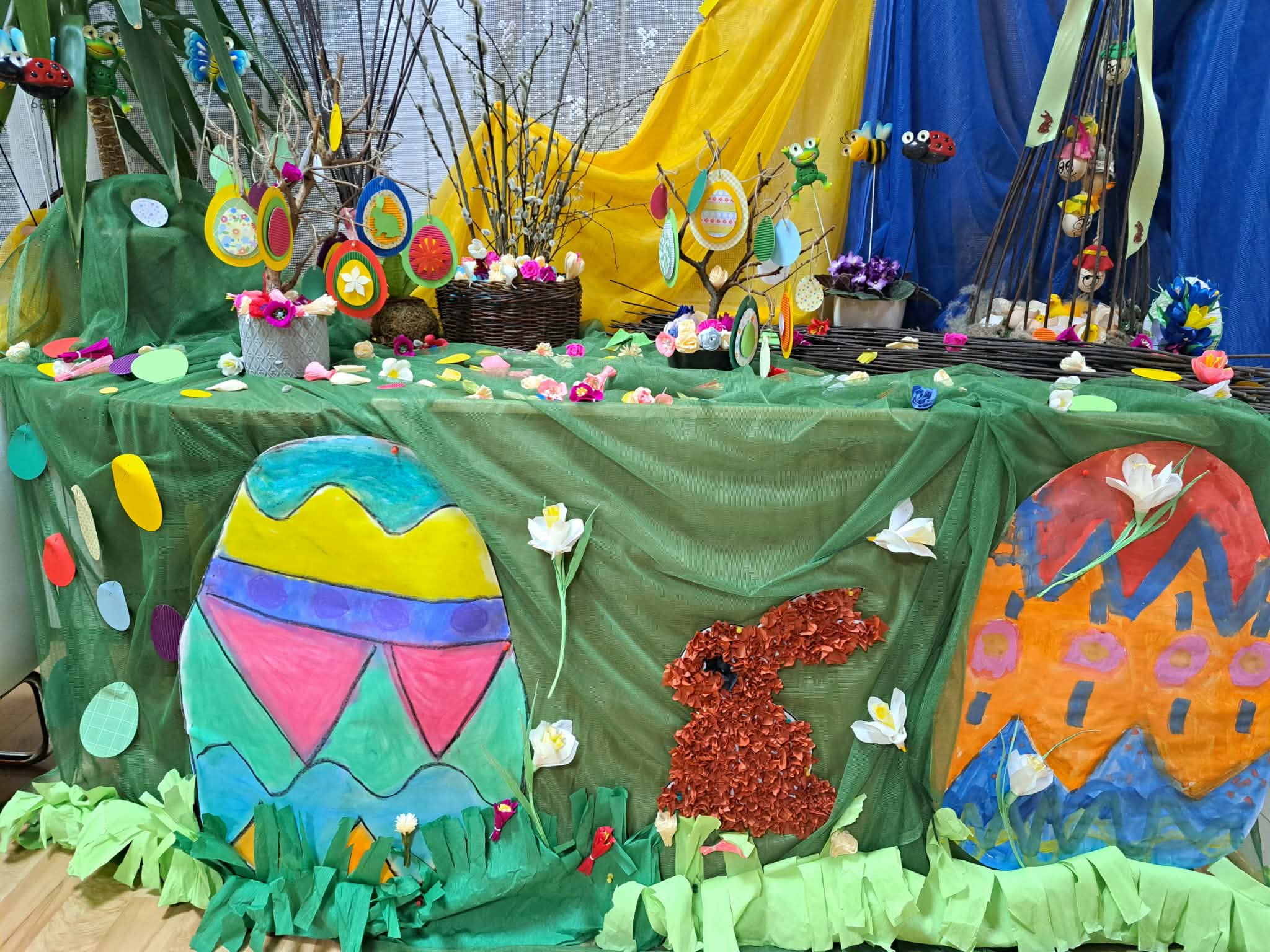 Zdjęcie przedstawia kolorową instalację wiosenną z pisankami i króliczkiem.