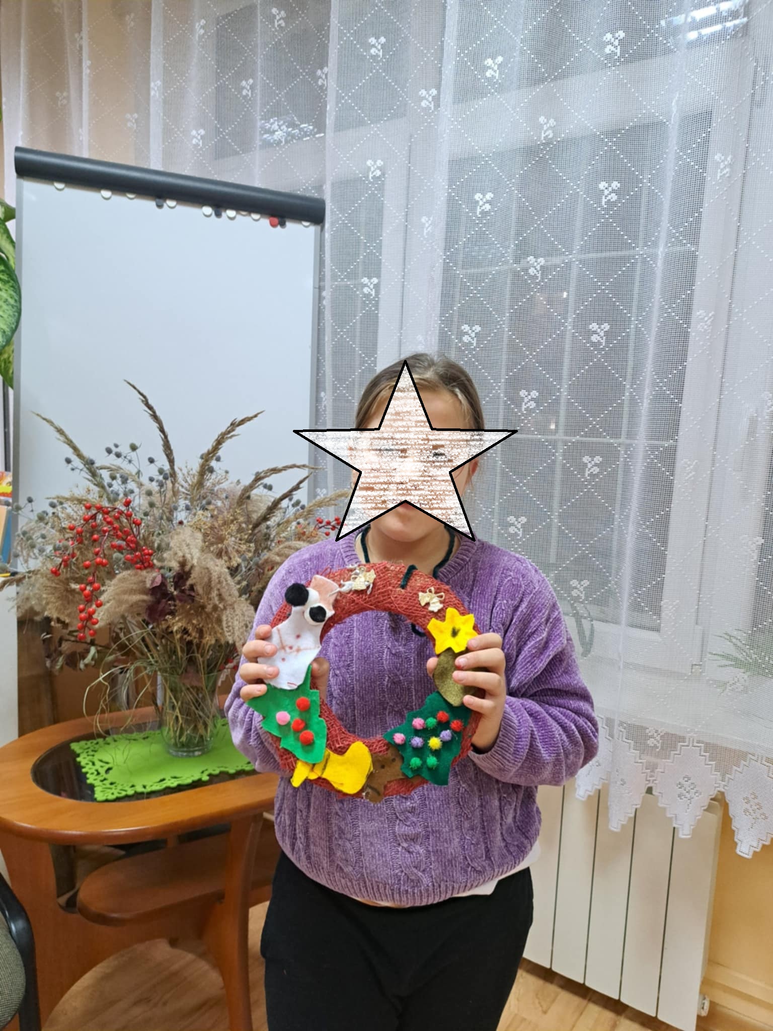 Dziewczynka pozująca z ozdobą świąteczną.