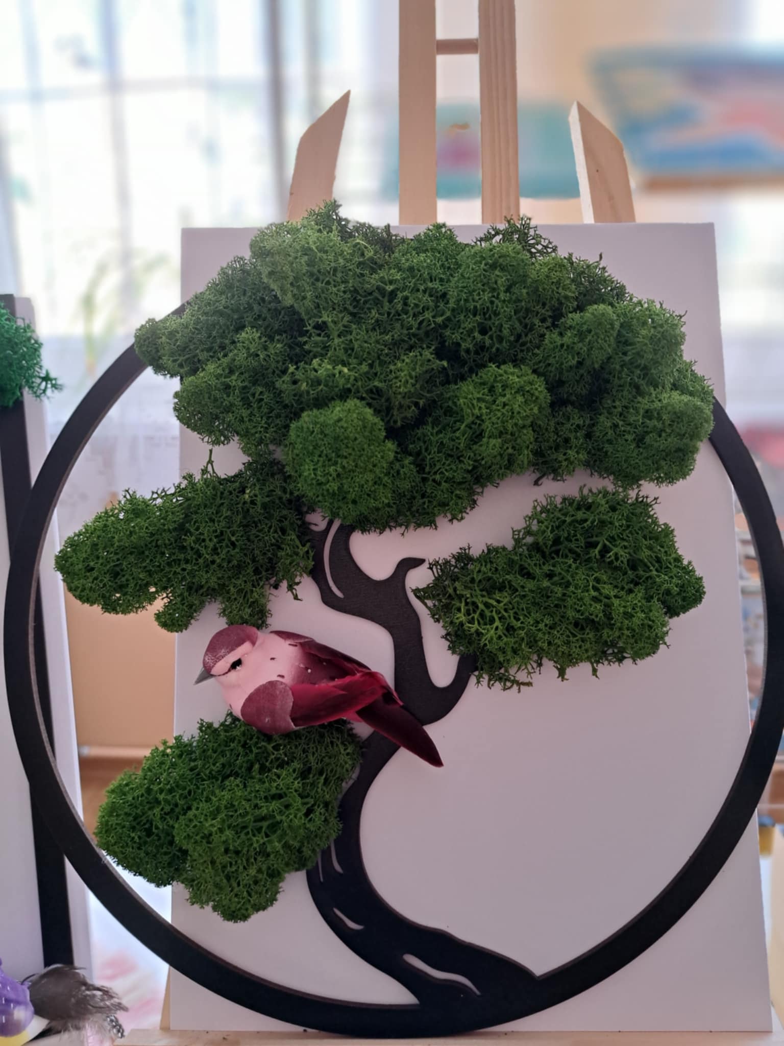 Drzewko z mchu na drewnianym okręgu.