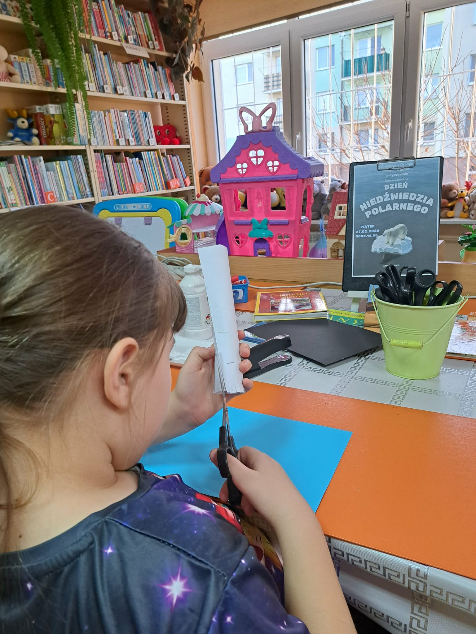 Dziewczynka wykonująca prace plastyczne.