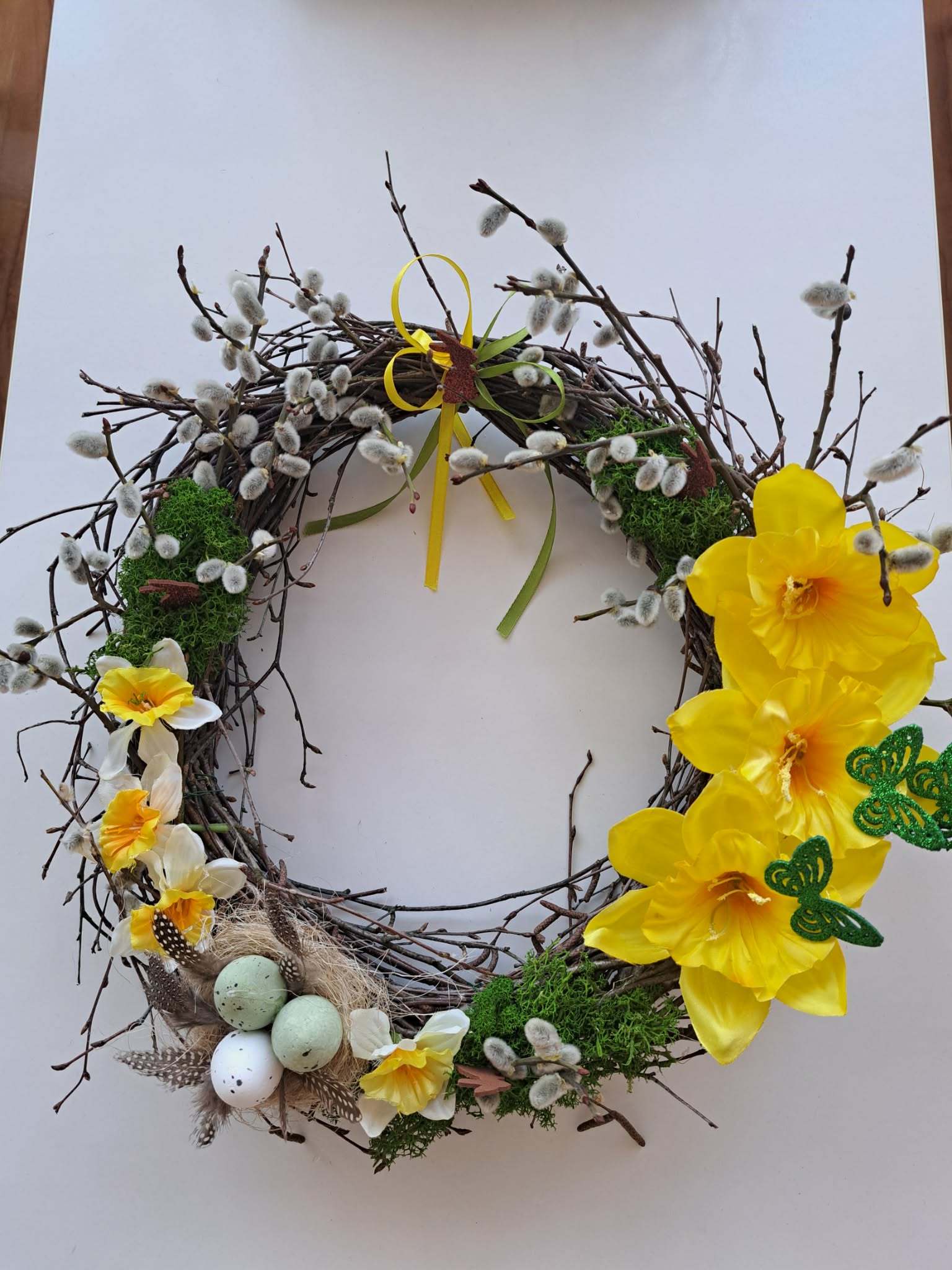 Zdjęcie przedstawia wianek wielkanocny zrobiony z witek brzozowych i ozdób.