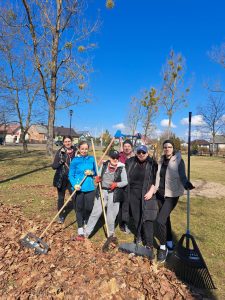 Grupa kobiet stoi z grabiami na rynku.