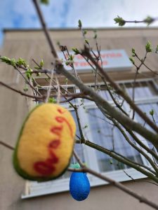 Pisanka stworzona metodą ozdabiania wełną czesankową, z napisem orange