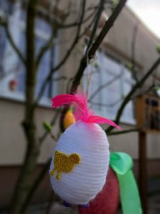 Na drzewku wisi zawieszona pisanka.