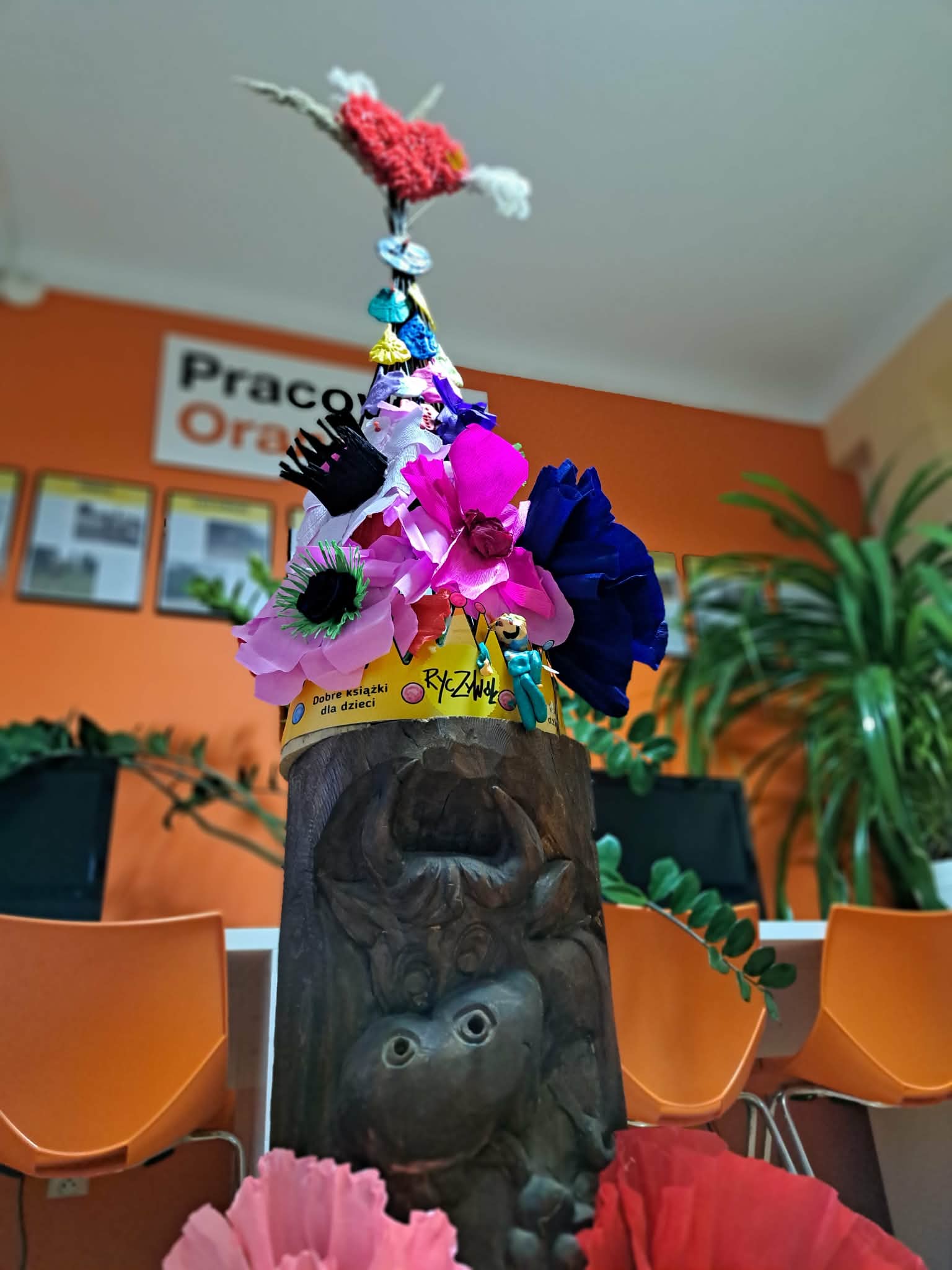 Zdjęcie przedstawia konstrukcję totemu ustrojoną w kolorowe kwiaty i emblematy wiosny.