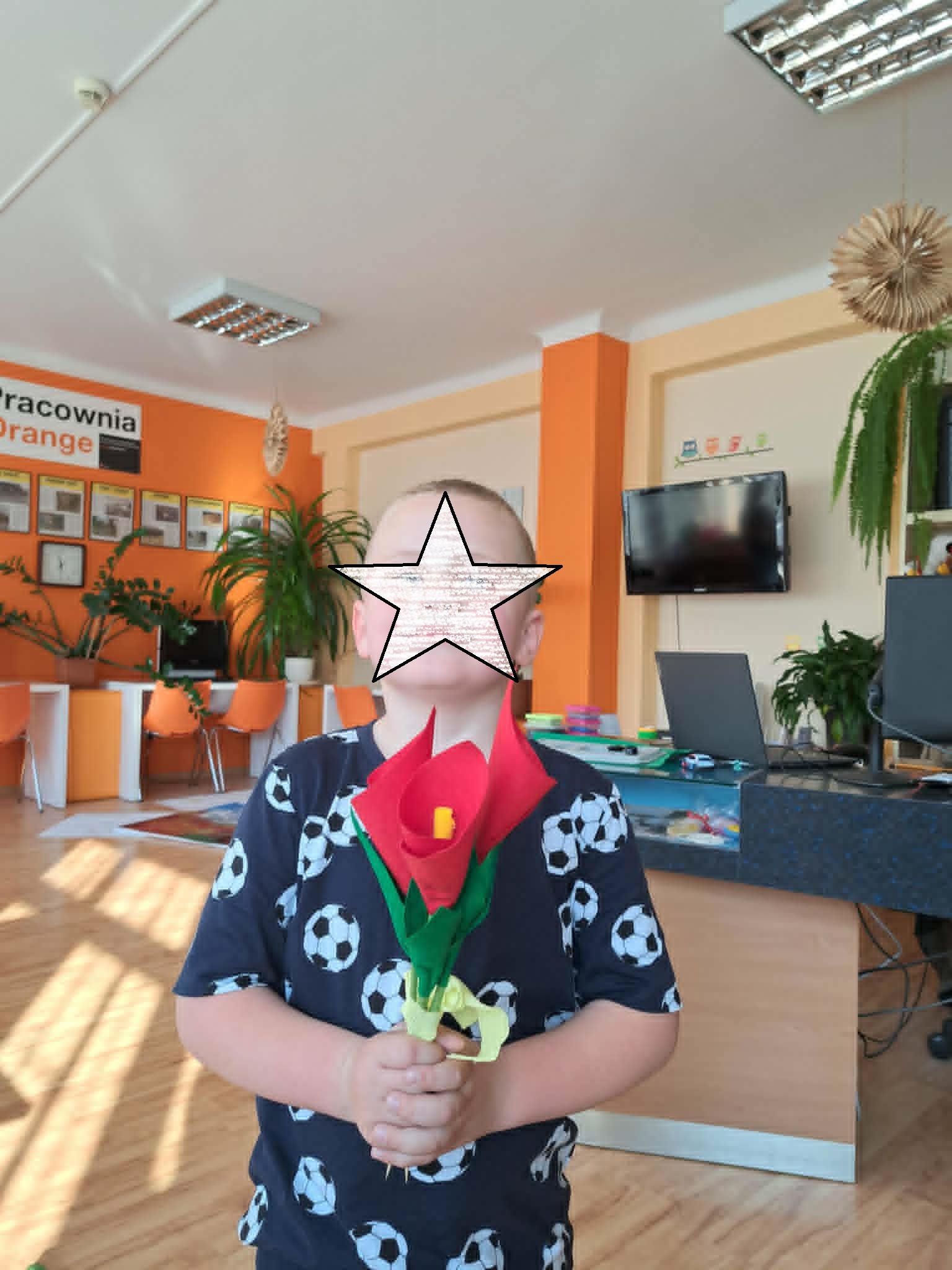 dziecko pozuje z wykonanymi kwiatami