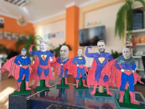 Na biurku stoją pomalowane przez dzieci figurki supermena.
