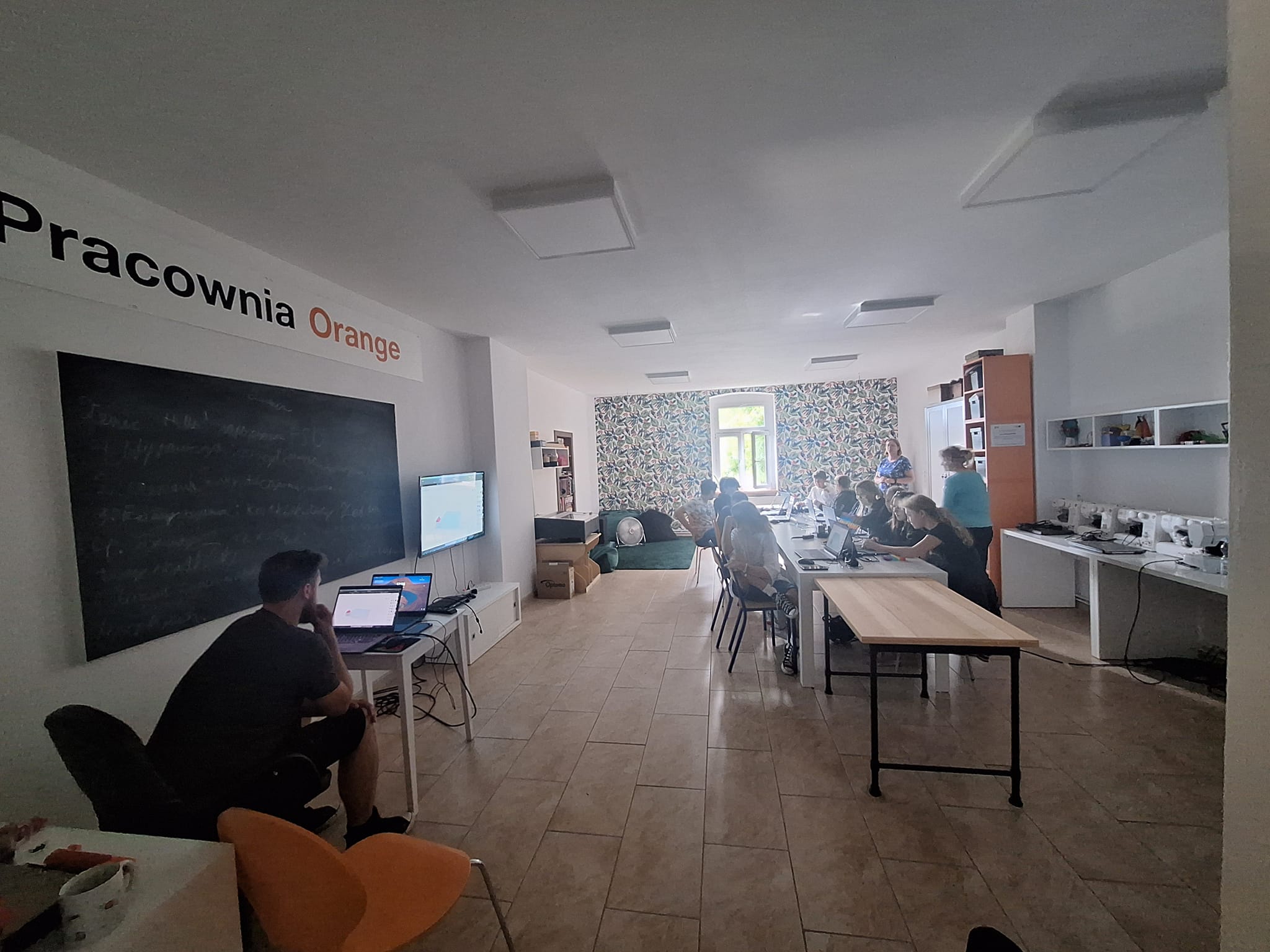 Grupa osób siedzących przy stole podczas szkolenia.