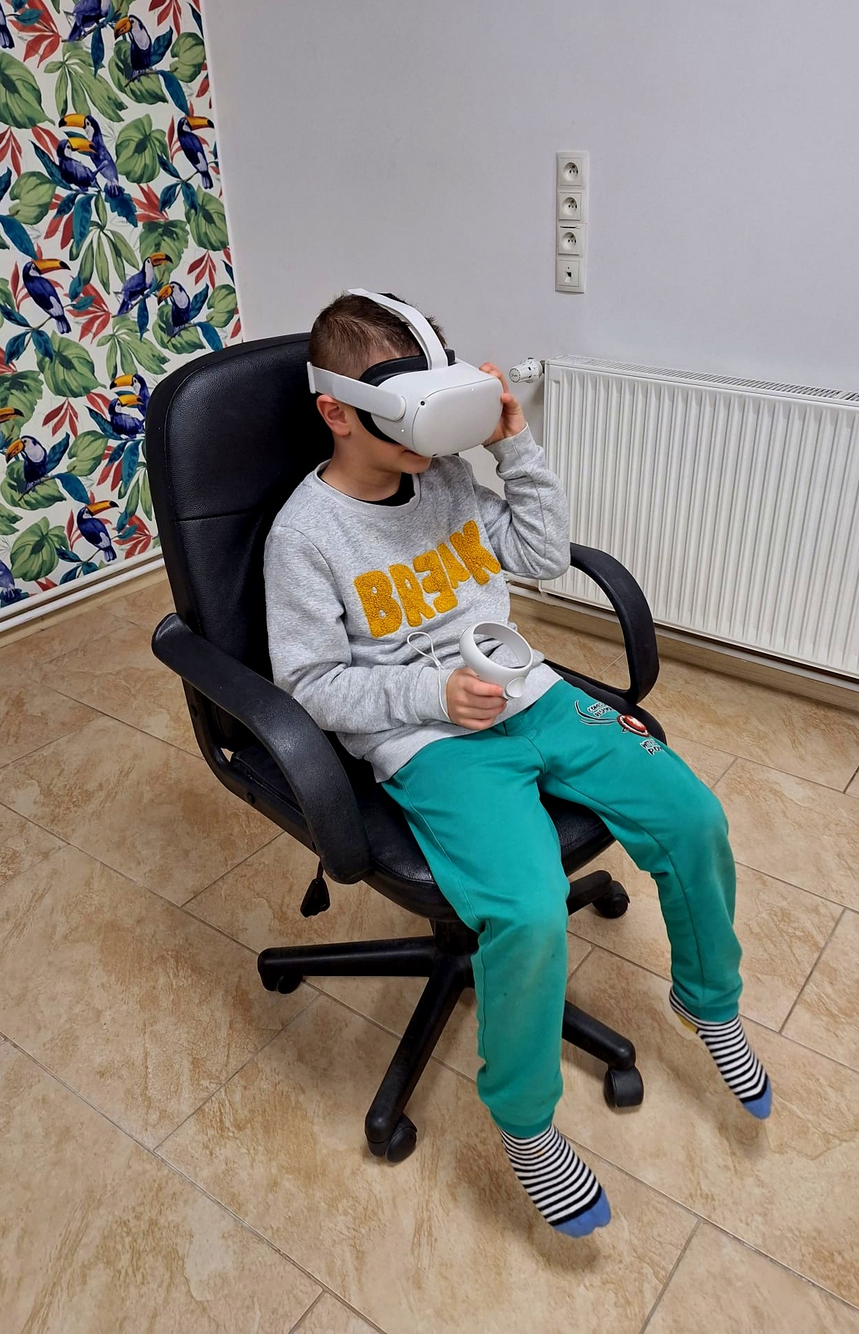 Chłopiec siedzący na fotelu w okularach VR.