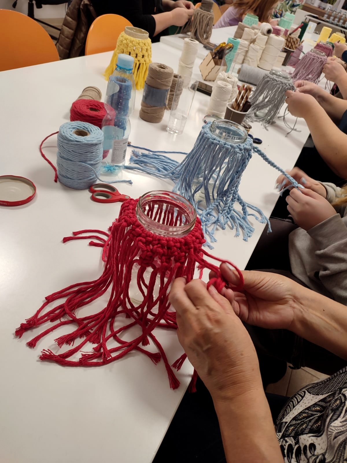 Słoiki na których zaplatana jest makrama.