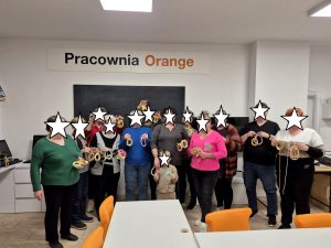 Uczestnicy warsztatów pozują z wykonanymi pracami.